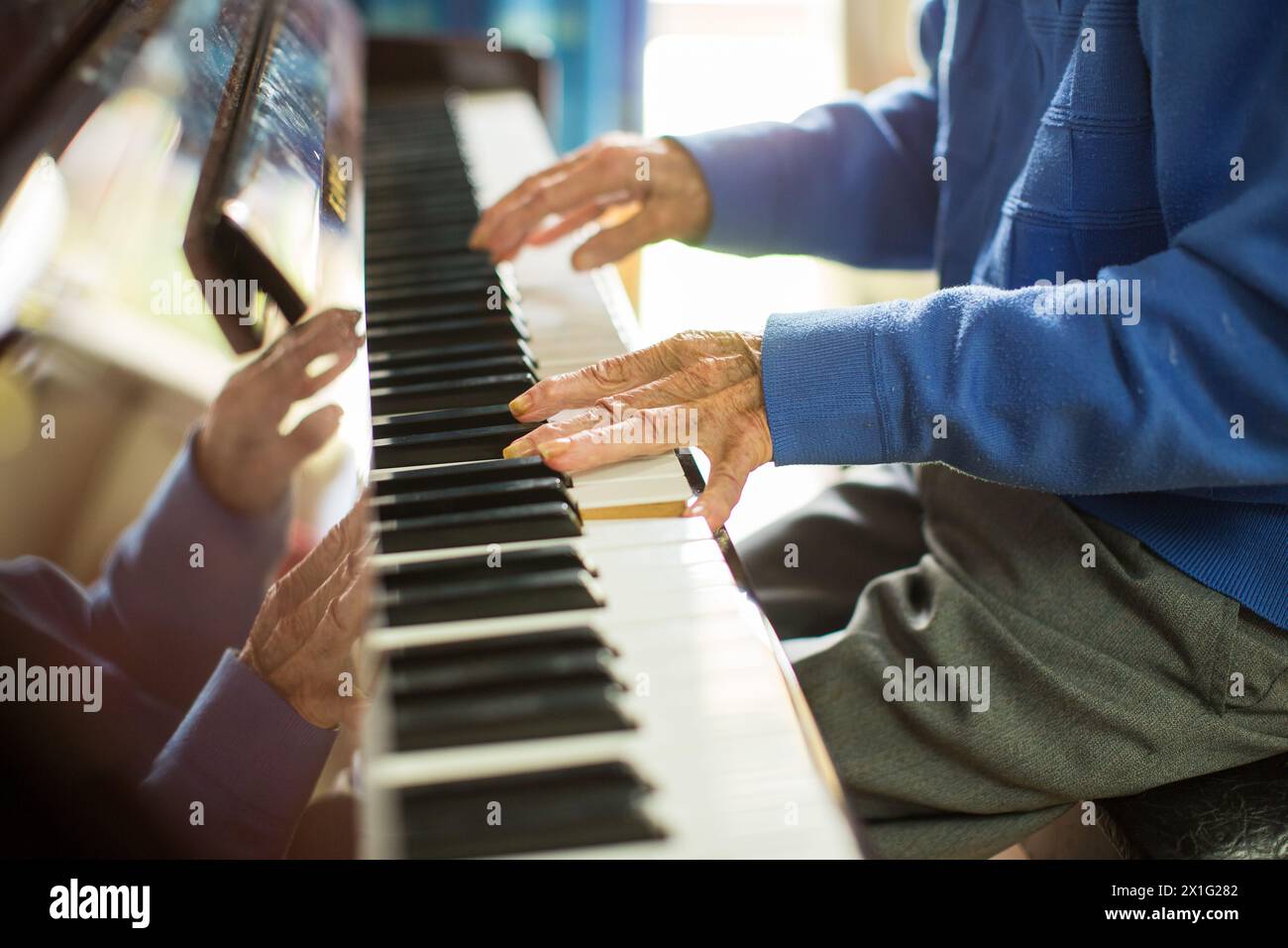 PENSIONNAIRE ÂGÉ D'UNE MAISON DE RETRAITE JOUANT DU PIANO. Banque D'Images