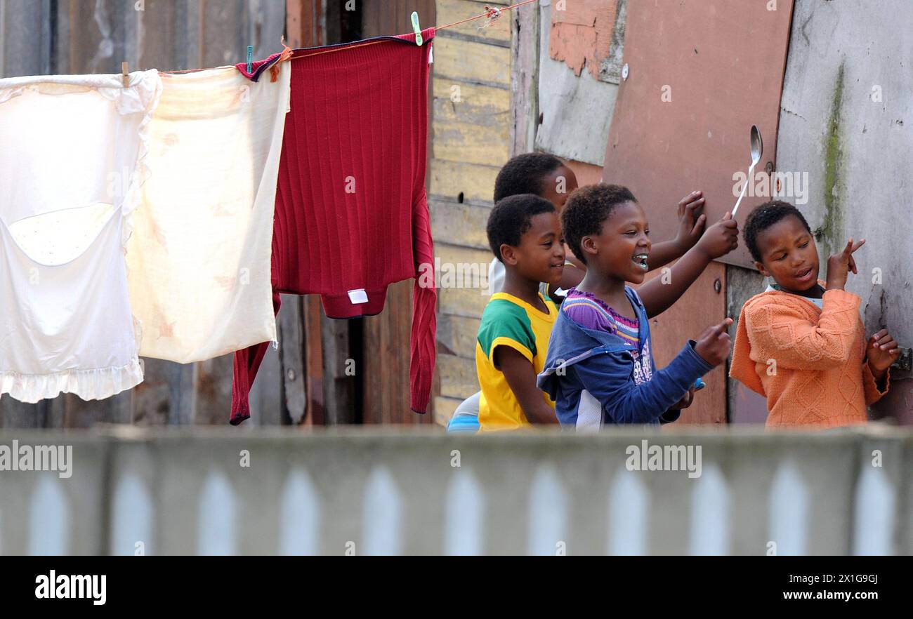 Le canton de Khayelitsha, troisième plus grand et à la croissance la plus rapide en Afrique du Sud, à la périphérie de Cape Town dans les Cape Flats, capturé le 5 juillet 2010. Dans l'image : des enfants regardant de loin l'entraînement de l'équipe nationale de football d'Uruguay. - 20100705 PD2332 - Rechteinfo : droits gérés (RM) Banque D'Images