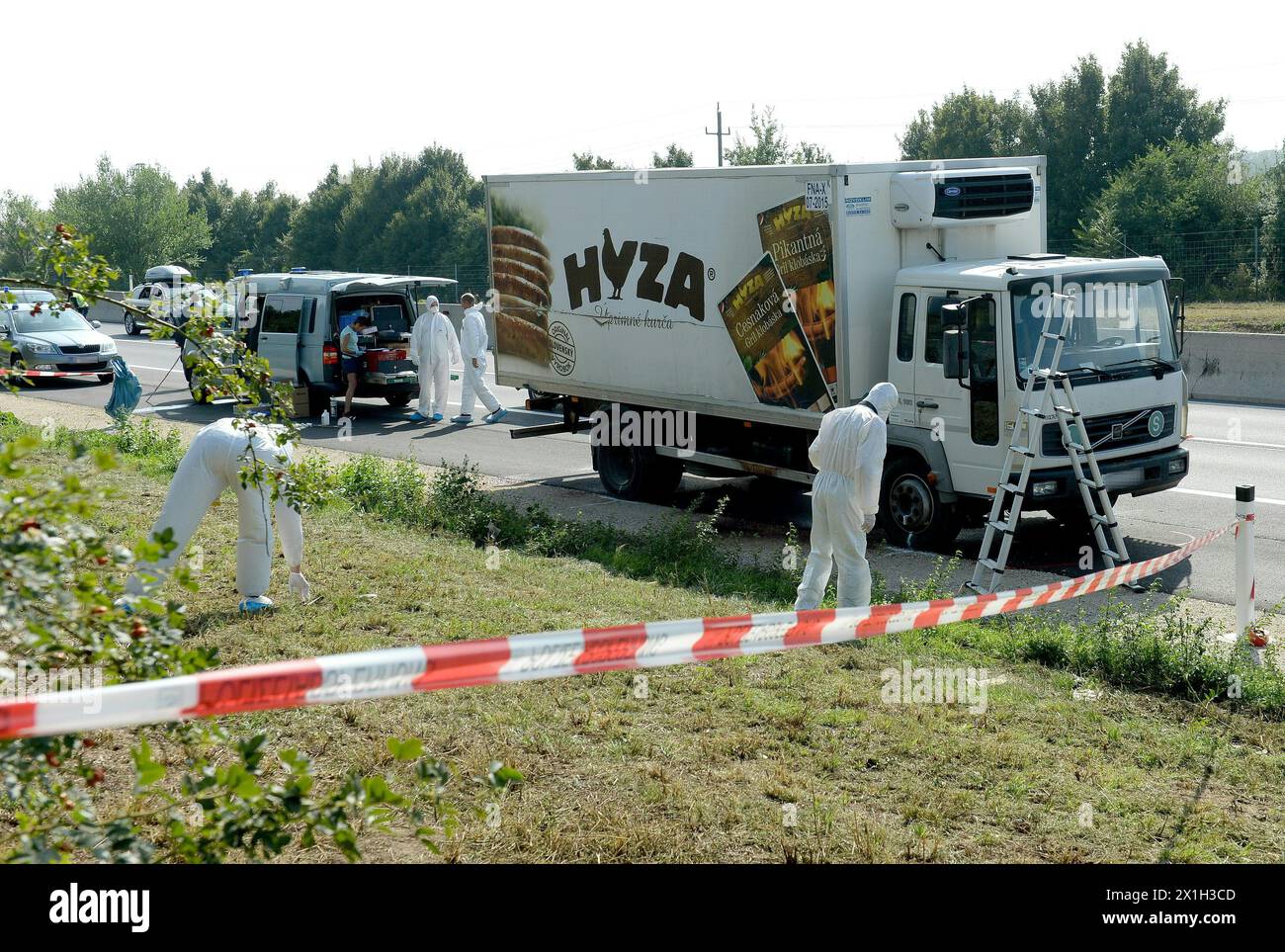 Des experts légistes enquêtent sur un camion dans lequel des réfugiés ont été retrouvés morts alors qu'il se trouvait sur l'autoroute A4 entre Parndorf et Neusiedl, Autriche, le 27 août 2015. Selon certaines informations, quelque 50 réfugiés auraient été retrouvés morts dans le camion garé à l'autoroute. Il ne peut être confirmé si les morts ont étouffé dans le camion, comme certains médias l'ont rapporté. Le camion a été découvert par des ouvriers de la route qui ont appelé la police. Le chauffeur a disparu, selon les médias. PHOTO : APA/ROLAND SCHLAGER - 20150827 PD6252 - Rechteinfo : droits gérés (RM) Banque D'Images