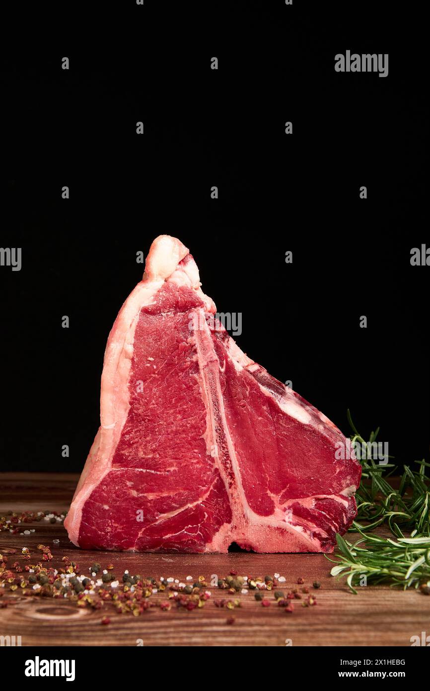 Morceaux de viande prime sur une table en bois sur un fond noir foncé Banque D'Images