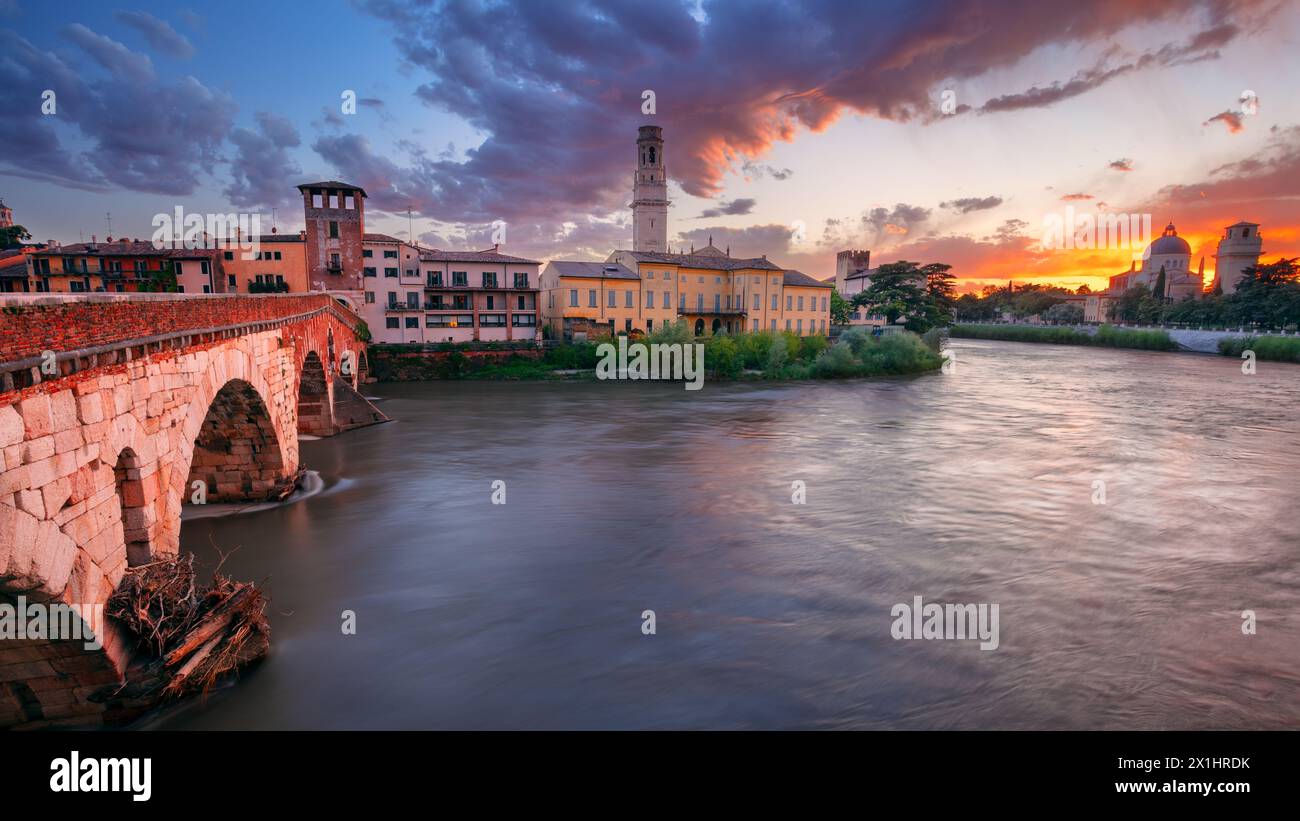 Vérone, Italie. Image de paysage urbain de la belle ville italienne de Vérone avec le pont de pierre au-dessus de la rivière Adige au coucher du soleil. Banque D'Images