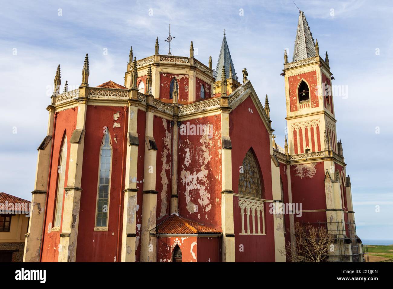 L'église paroissiale rouge vif de San Pedro ad Venceya, avec deux tours, dans le néo-gothique français et l'Indiano. Cóbreces, Cantabrie, Espagne. Banque D'Images