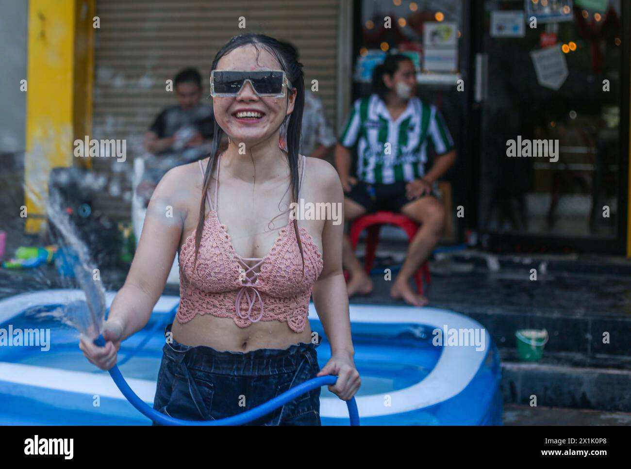 Mae Sot, Thaïlande. 16 avril 2024. Une dame joue avec des éclaboussures d'eau pendant le festival Songkran à Mae Sot. Des milliers de fêtards arpentaient la rue de Mae Sotto pour célébrer le Songkran ou le nouvel an thaïlandais. Le festival 'Songkran', également connu sous le nom de festival de l'eau, qui tombe chaque année le 13 avril. Le mois le plus chaud de l'année en Thaïlande. La reconnaissance officielle par l'UNESCO du Songkran, le festival traditionnel du nouvel an thaïlandais, en tant que patrimoine culturel immatériel de l'humanité. Crédit : SOPA images Limited/Alamy Live News Banque D'Images