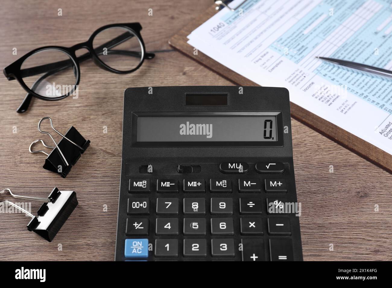 Comptabilité fiscale. Calculatrice, document, lunettes et papeterie sur table en bois, gros plan Banque D'Images