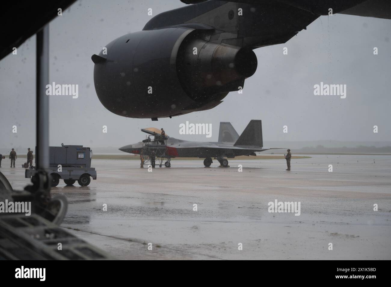 Les forces de sécurité de l'US Air Force et les aviateurs de maintenance affectés à la 3rd Air Expeditionary Wing reçoivent et préparent un F-22 Raptor pour la configuration Banque D'Images