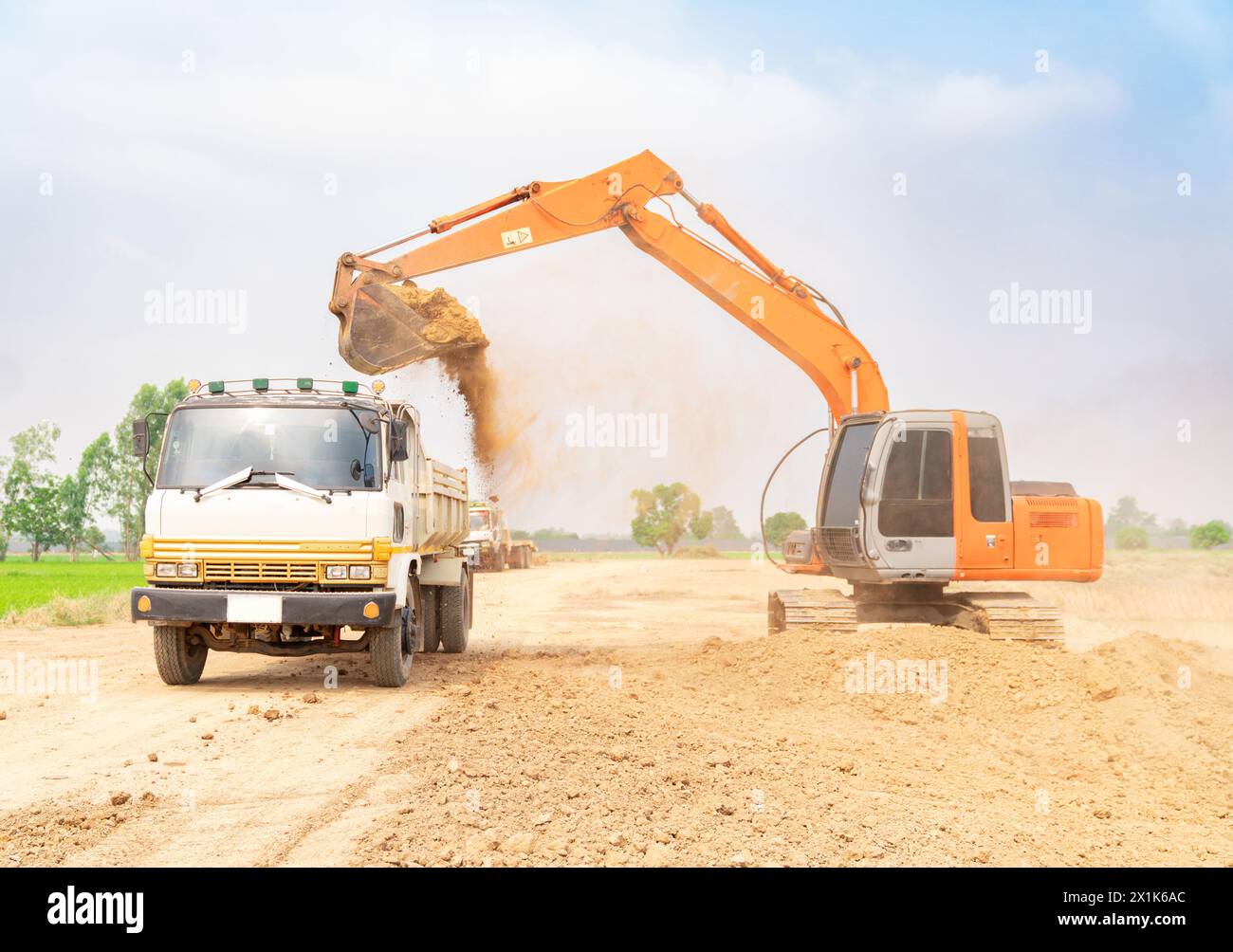 Machine de construction d'excavatrice chargeant le sol dans le camion à benne basculante. Banque D'Images