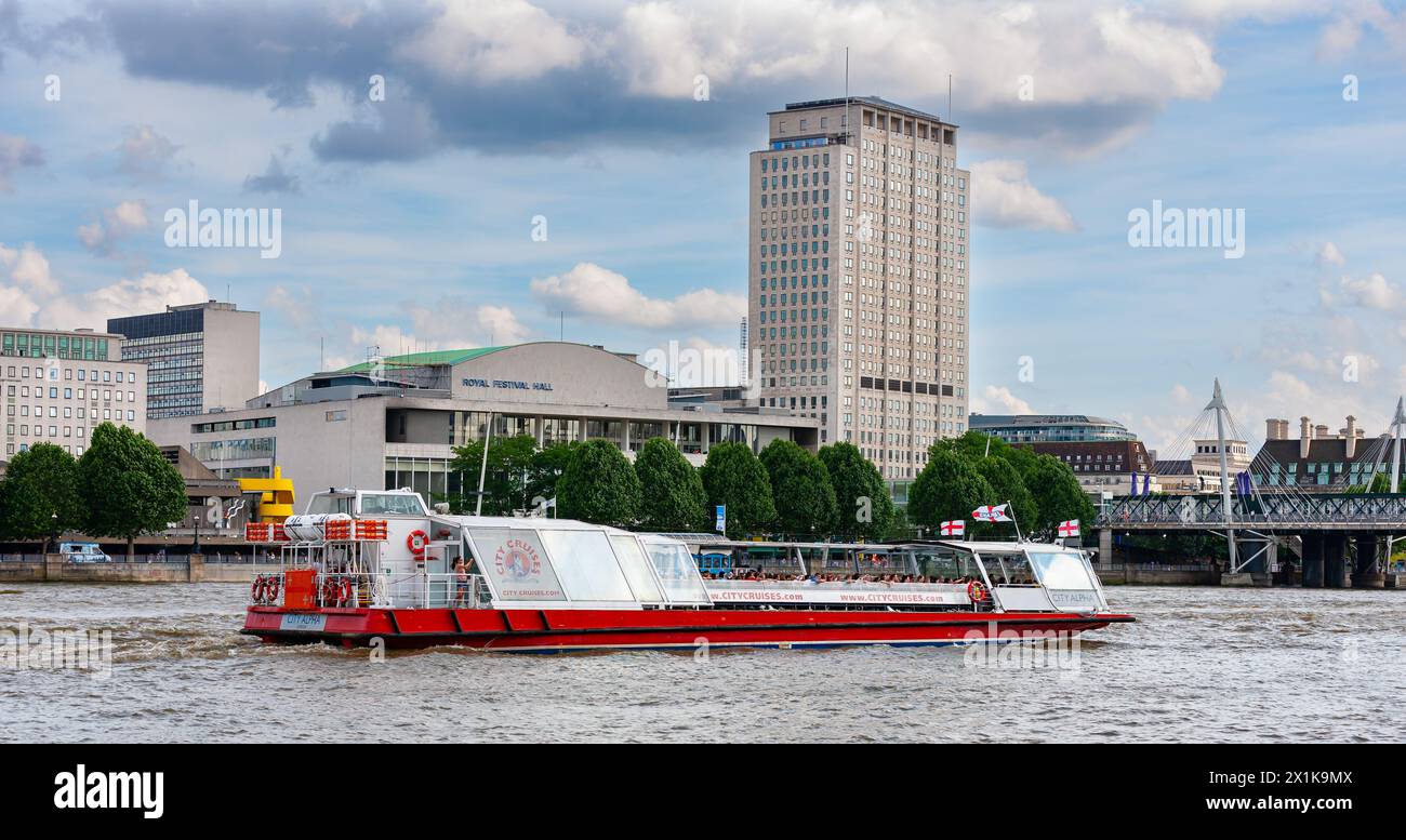 Londres, Royaume-Uni - 29 juin 2010 : bateau d'excursion sur la Tamise devant le Royal Festival Hall, rive est. Banque D'Images Londres, Royaume-Uni - 29 juin 2010 : bateau d'excursion sur la Tamise devant le Royal Festival Hall, rive est. Banque D'Images