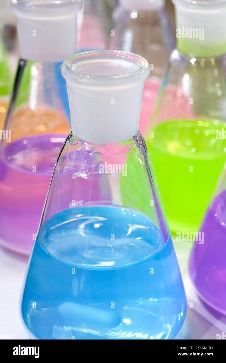 Liquides multicolores dans des flacons coniques de laboratoire chimique, gros plan, mise au point sélective, fond de chimie abstrait Banque D'Images