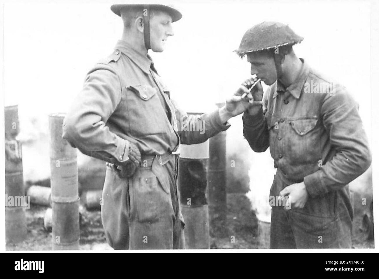 Le soldat Rowley de Hull donne une lumière au soldat Clark de Cwmbran lors d'une pause de l'exploitation des générateurs de fumée, illustrant l'activité de routine dans l'armée britannique, 21e groupe d'armées, Europe du Nord-Ouest, 1944-1946. Banque D'Images