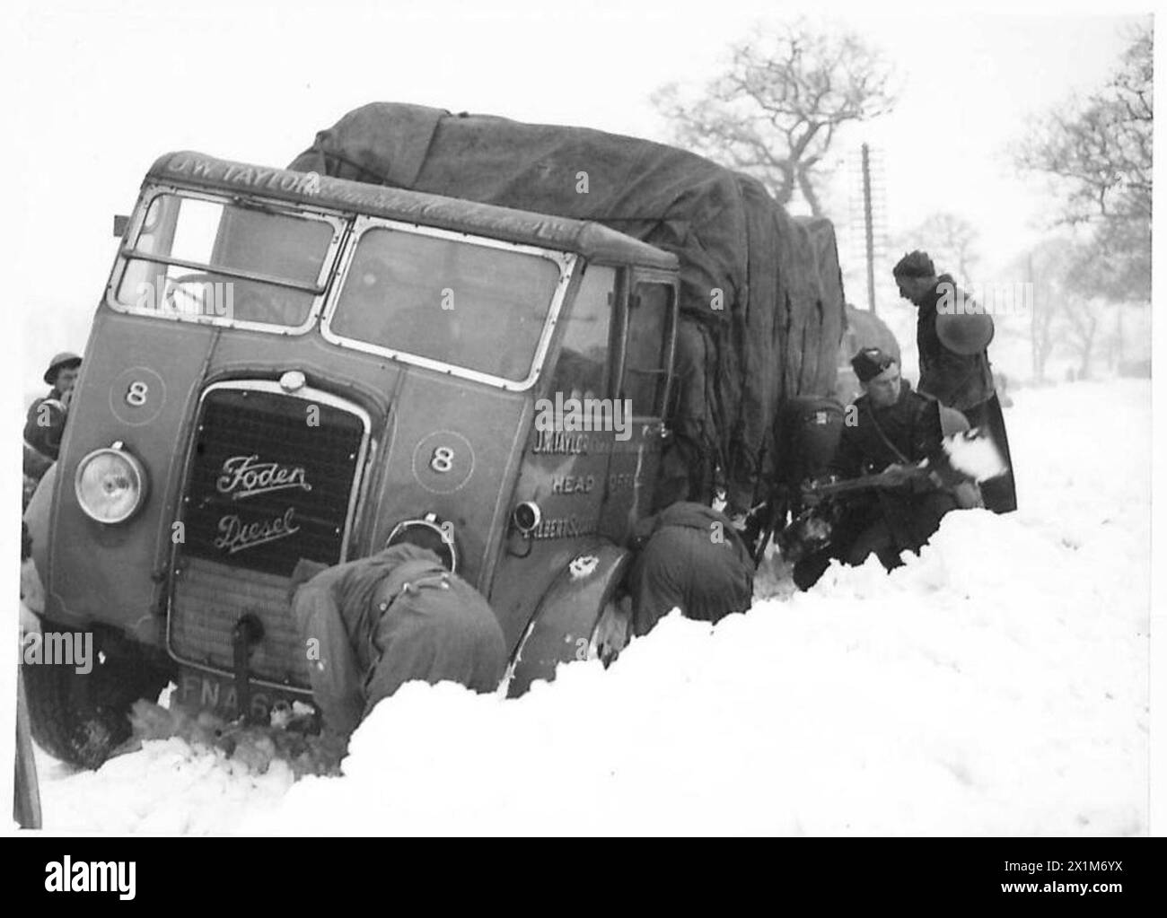 Les troupes de l'armée britannique aident à creuser un camion coincé dans la neige sur la route Whitchurch-Chester, illustrant le soutien sur le terrain et le travail d'équipe dans des conditions hivernales. Banque D'Images