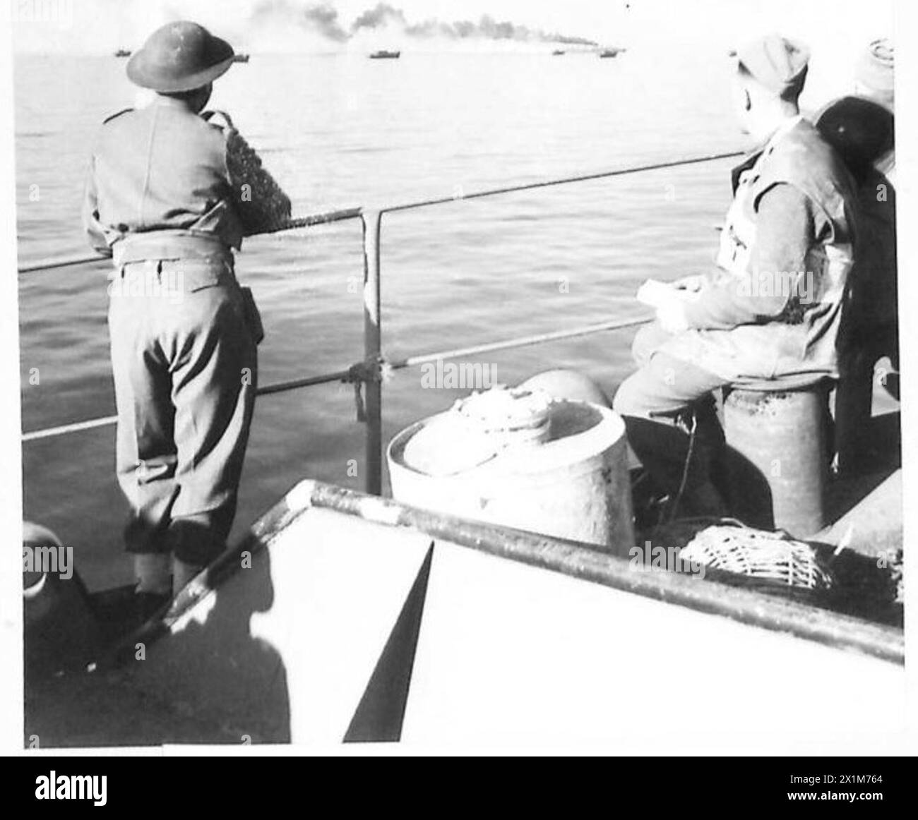 Sgmn. G.E. Boucher et DVR. A. Vert observer un véhicule détruit posant un écran de fumée lors des débarquements alliés au sud de Rome en présence de membres de l'armée britannique. Banque D'Images