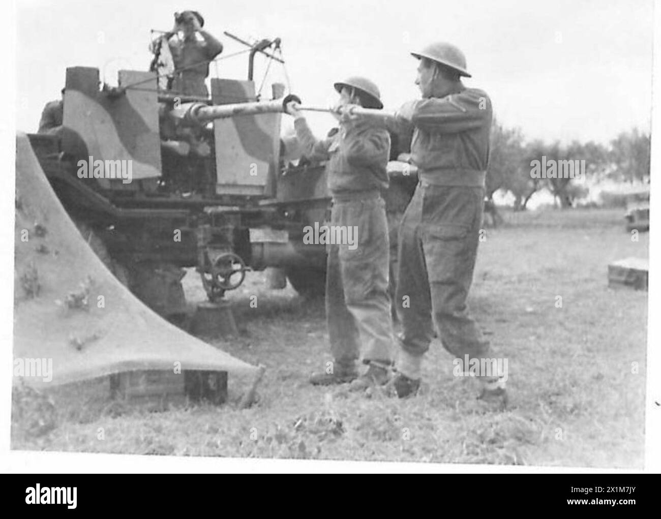 ITALIE : HUITIÈME ARTILLERIE ARMYMOBILE - après chaque tir, le canon du canon est tiré à travers, mais la veille pour l'avion ennemi continue tout au long. Les hommes qui travaillent sont :- l/Bdr. R.A. Poxon (caméra la plus proche) de 39 Princes Park Lane, Hayes, Middx, et (à gauche) Gun. H. Minsull du 32 Williams Street, Newtown, Chester, armée britannique Banque D'Images