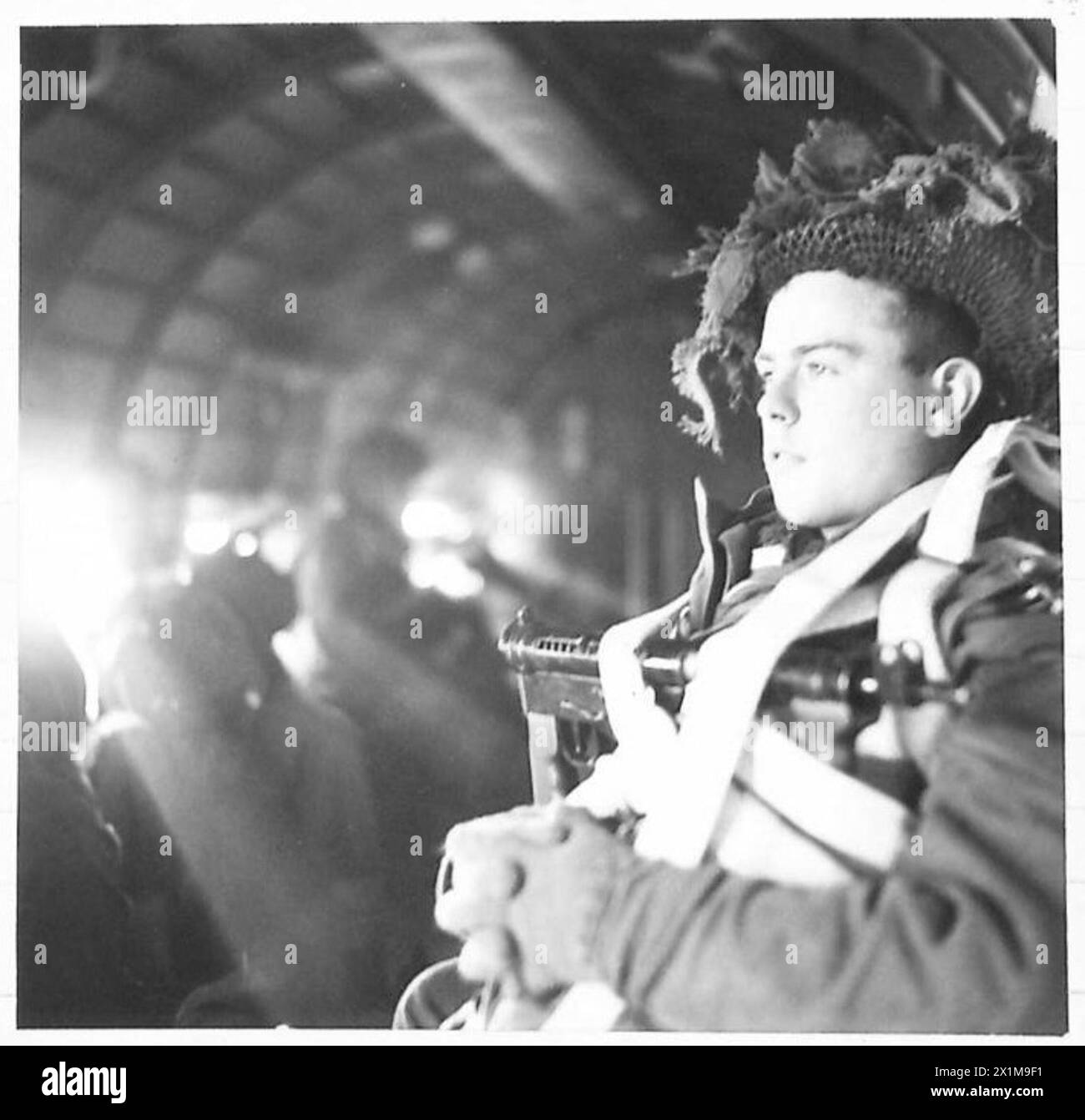 Un parachutiste est assis dans un avion Dakota en route vers l'Allemagne lors des premières opérations aéroportées de l'armée britannique. Banque D'Images
