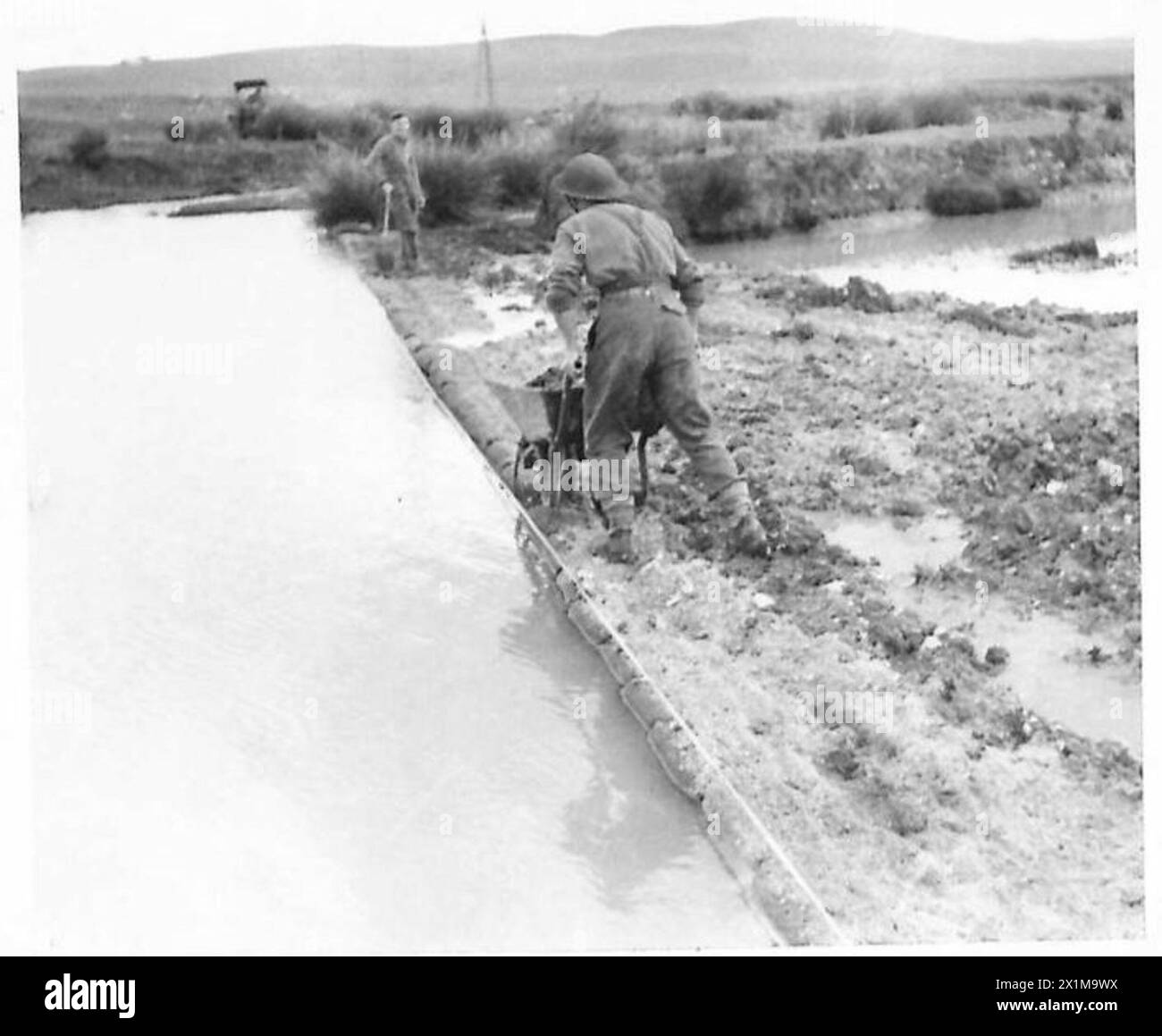 Les ingénieurs de la 1256e compagnie de campagne les ingénieurs royaux construisent un barrage en sac de sable et positionnent la tuyauterie pendant la construction de la route près de Beja lors de la campagne de Tunisie, le 29 décembre 1942. Les lignes d'approvisionnement et la construction de routes étaient essentielles pour le transport de munitions et de fournitures dans les zones avancées, où les routes étaient mauvaises et les ponts causaient un trafic à sens unique. Banque D'Images