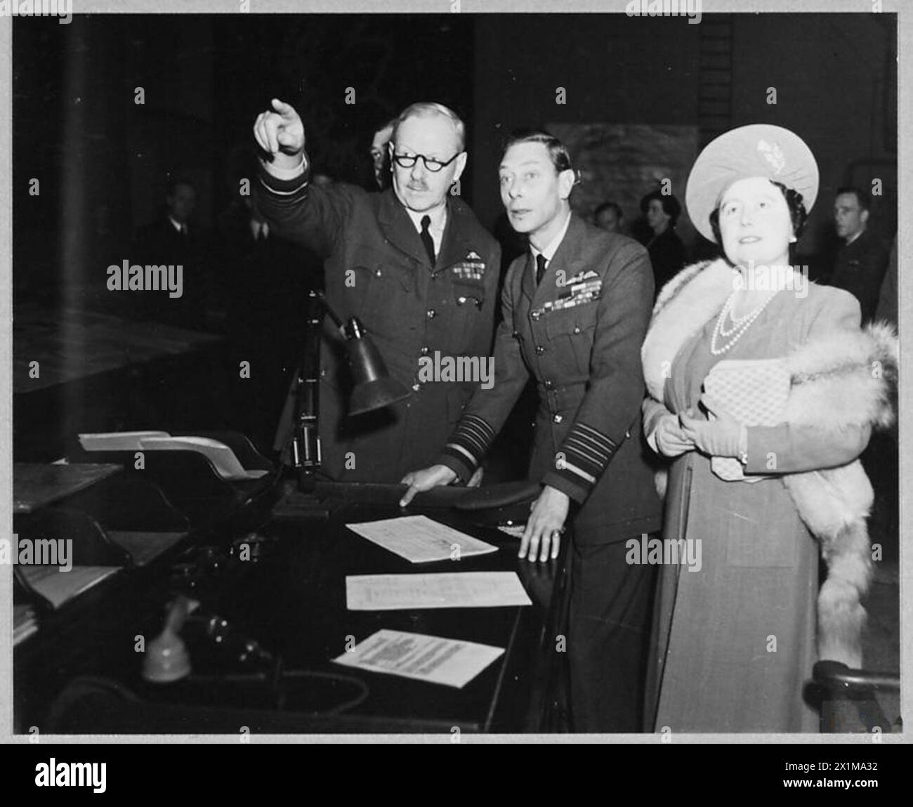 LE ROI et LA REINE VISITENT LE COMMANDEMENT DES BOMBARDIERS - le roi et la reine ont effectué une visite privée au quartier général du commandement des bombardiers R.A.F. dans le pays aujourd'hui, 7 février 1944. Le roi et la reine ont parlé aux hommes qui dirigent l'offensive aérienne britannique. Le maréchal en chef Sir Arthur T. Harris, KCB., OBE., AFC., commandant en chef du commandement des bombardiers, montre à leurs Majestés la salle des opérations de la Royal Air Force Banque D'Images