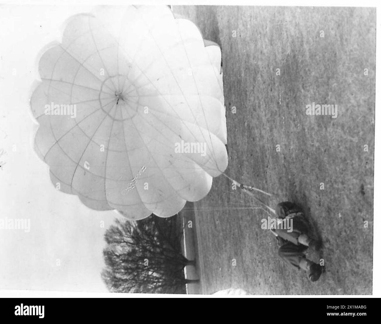 L'ARMÉE POLONAISE EN GRANDE-BRETAGNE, 1940-1947 - après avoir débarqué après un saut d'une tour de parachute, un parachutiste apprend à contrôler son parachute pour l'empêcher de le traîner au-dessus du sol. Photographie prise à Lundin Links. La première étape dans la formation des parachutistes est la bonne façon d'atterrir. Dans ce centre polonais de formation de parachutistes à Largo House, Fifeshire, des soldats de la 1re brigade indépendante polonaise de parachutistes sont vus recevoir leur instruction initiale de débarquement. De là, ils poursuivent à travers les différentes étapes du parcours pour se donner enfin l'énergie comme parachutistes à part entière. Noir et blanc Banque D'Images