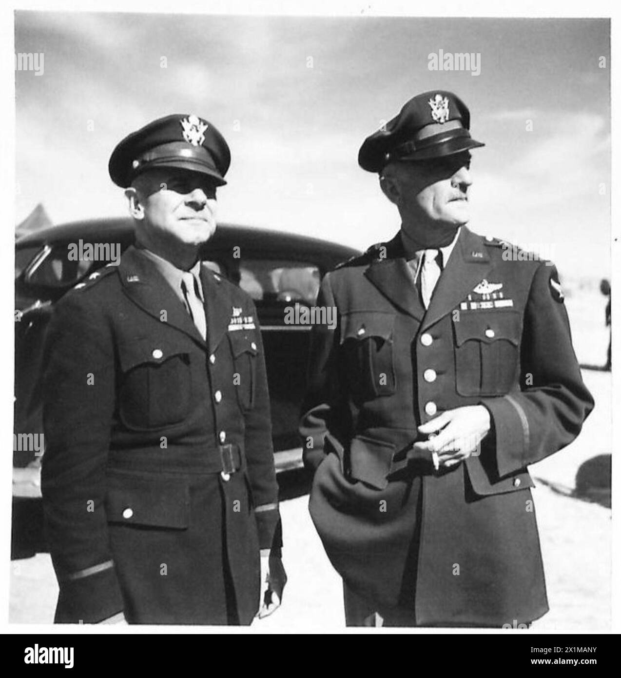 Le Lieutenant Gen. Spaats et le général Doolittle attendent l'arrivée d'officiers turcs dans un aéroport lors d'une visite en Afrique du Nord, illustrant des opérations de liaison militaire. Banque D'Images