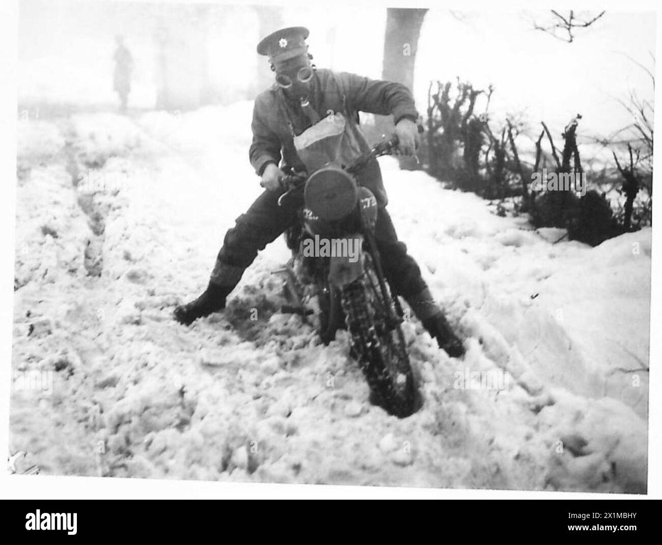 Un motocycliste de l'armée britannique navigue dans la neige profonde en Irlande du Nord, présentant des défis de mobilité et des exercices d'entraînement hivernal. Banque D'Images