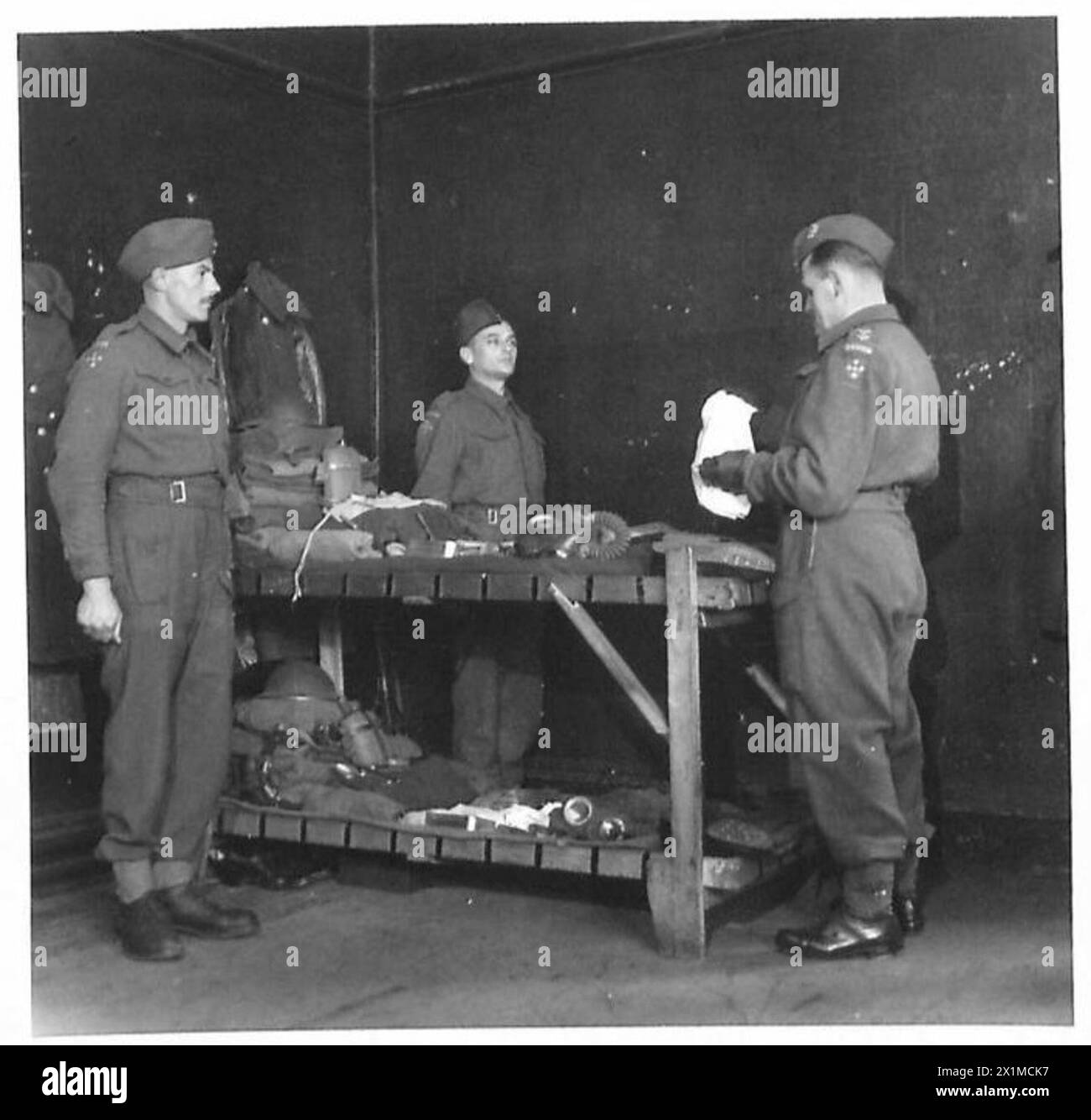 Les troupes de l'armée britannique font inspecter leur équipement par un officier, illustrant les contrôles militaires de routine et la préparation opérationnelle. Banque D'Images