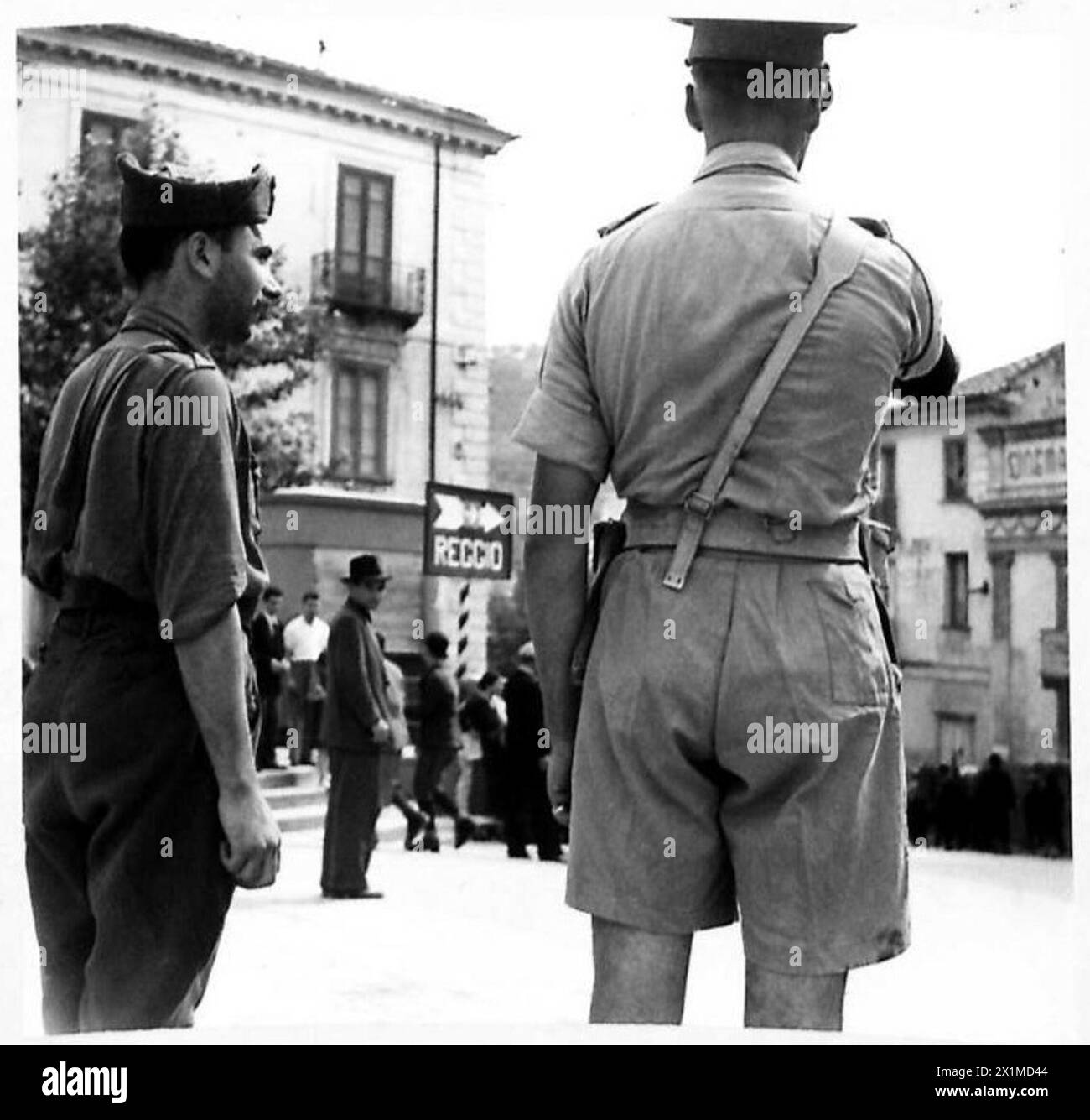 La police militaire britannique dirige la circulation et prend le contrôle des routes pendant l'invasion de la Sicile, tandis que les carabiniers italiens observent l'opération, montrant la coordination et la police militaire. Banque D'Images