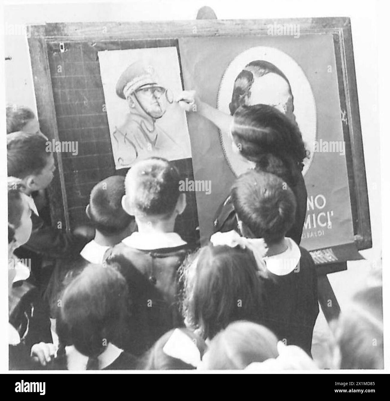 Les enfants d'Apricena, en Italie, reprennent leurs études après trois ans, les salles de classe débarrassées des symboles fascistes, remplacées par le portrait de la reine, reflétant les réformes éducatives post-occupation sous la supervision des Alliés. Banque D'Images