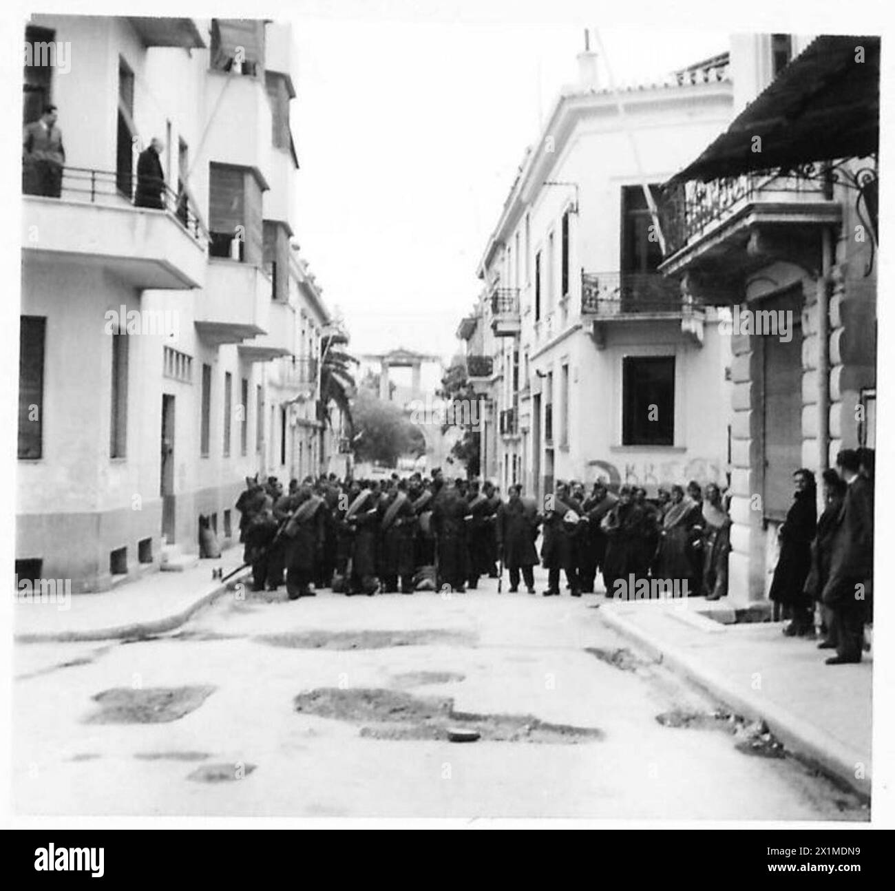Des membres de la Garde nationale verte attendent dans les rues latérales d'Athènes pour patrouiller après la tombée de la nuit près de l'Arc d'Hadrien, dans une zone patrouillée pour la sécurité, l'armée britannique. Banque D'Images