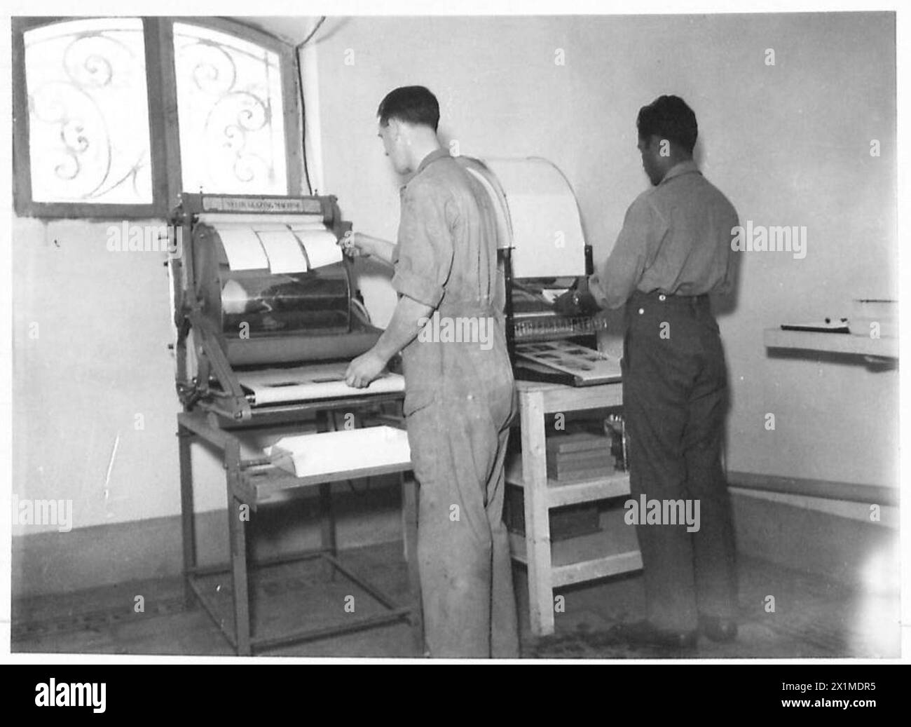 L'Army film and Photographic Unit (AFPU) émaille des tirages photographiques à l'aide de machines de vitrage modernes après le développement et le lavage de l'armée britannique. Banque D'Images