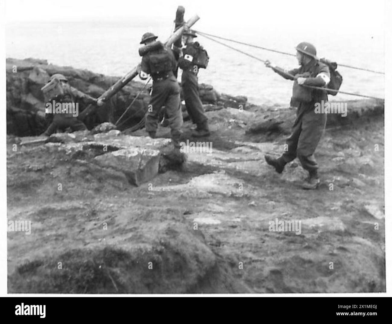 NOUVELLE MÉTHODE DE SAUVETAGE DES VICTIMES DES FALAISES - montage de l'appareil au sommet de la falaise avant la démonstration. Un patient brancard étant rendu rapide à l'appareil pour descendre la falaise, l'armée britannique Banque D'Images