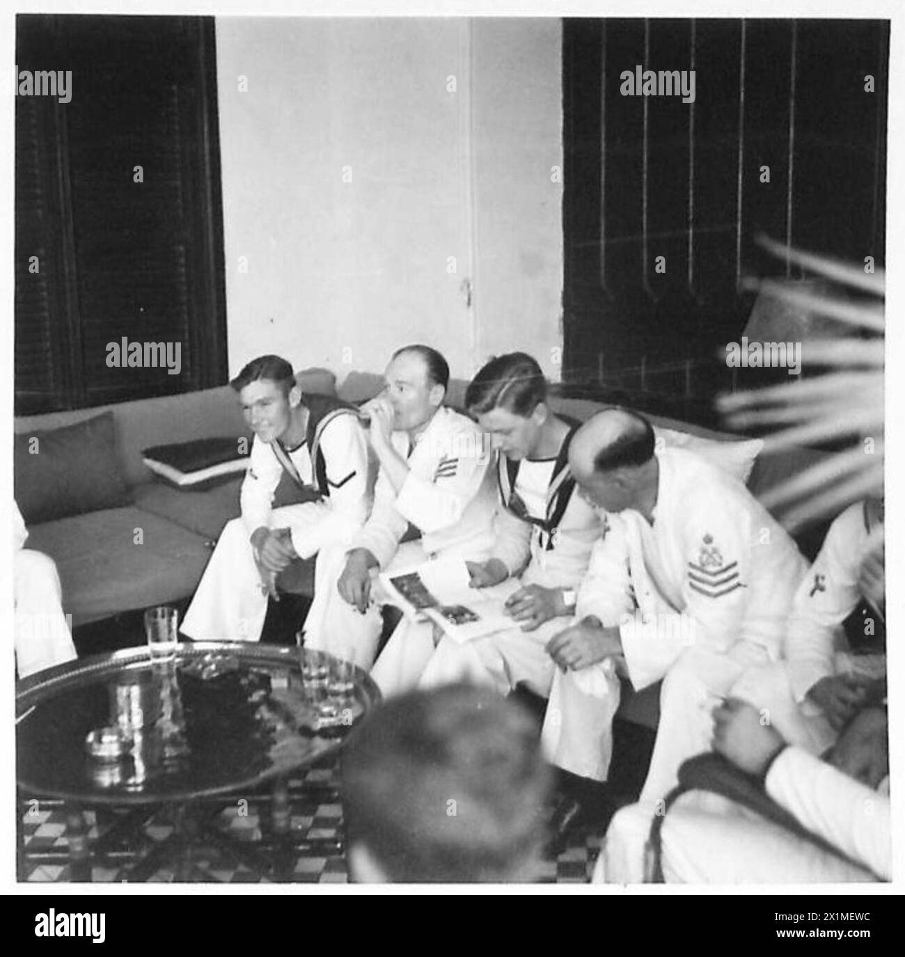 SAR El Emir Mansur Ibn Saoud visite Djeddah, accompagné d'une escorte navale, qui prend des rafraîchissements dans les bureaux de la Standard Oil Company après la visite. Banque D'Images