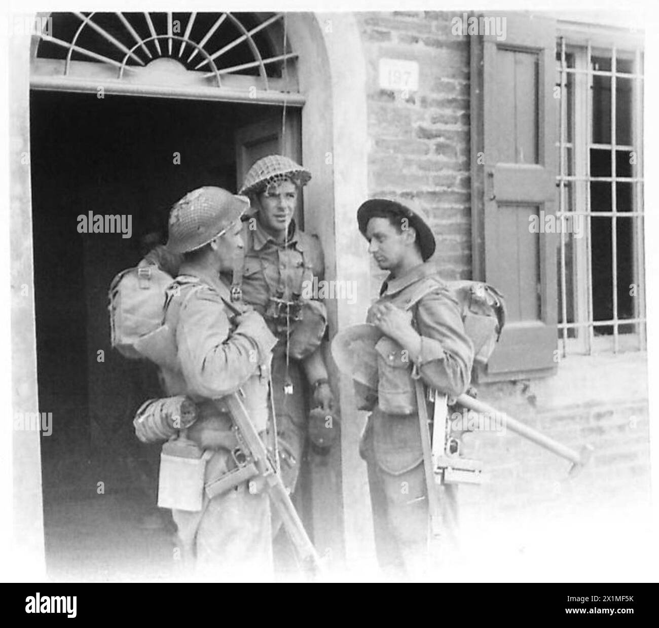 HUITIÈME ARMÉE : INFANTERIE CAPTURE FILO - trois fantassins britanniques se reposent dans le shlter d'une porte d'une maison. Ce sont :- Cpl. Humphries de Maidstone, Kent l/Sgt. Rose of Yarmouth Sgt. Mines de Bristol, armée britannique Banque D'Images