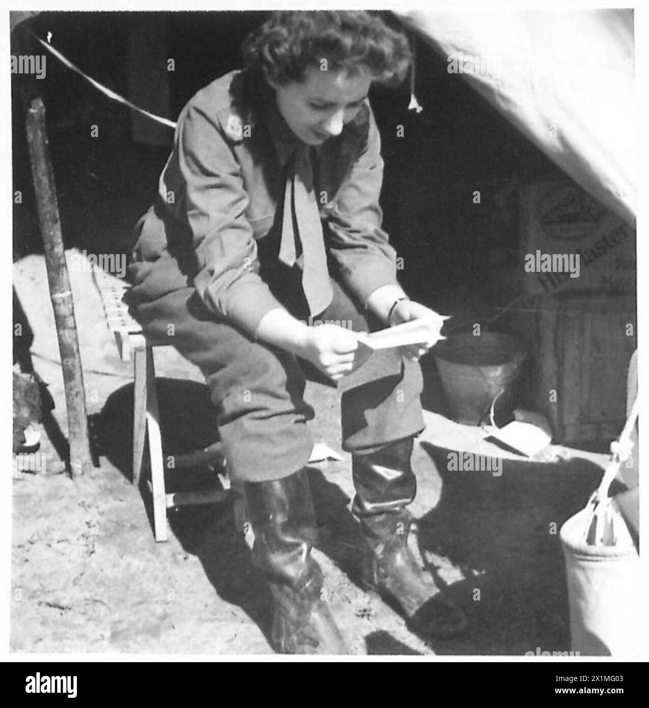 ITALIE : CINQUIÈME armurses DANS LA TÊTE DE PONT D'ANZIO - sœur Meakin - voir N.A.12406 - assise dans la porte de sa tente lisant une lettre de chez elle. Elle a deux ans de service à l'étranger à son actif ; a servi en Égypte, en Afrique du Nord, en Sicile, dans le sud de l'Italie et maintenant à Anzio, dans l'armée britannique Banque D'Images