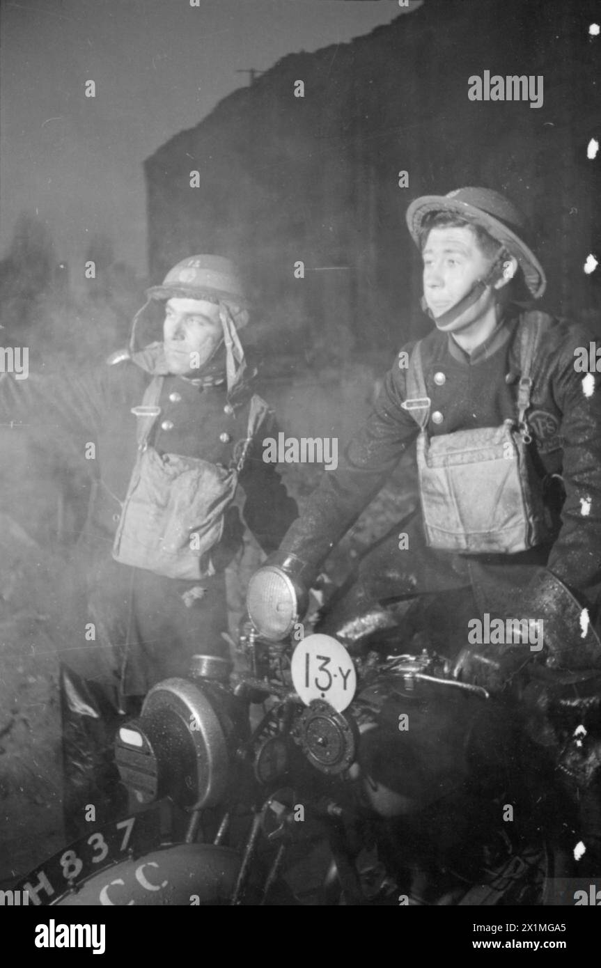 Les hommes du Service d'incendie auxiliaire de Londres, vers 1940, rapportent des gens piégés dans le sous-sol d'un bâtiment. Un officier informe un préposé à l'expédition, qui transmet l'information au quartier général et aux services médicaux. Banque D'Images
