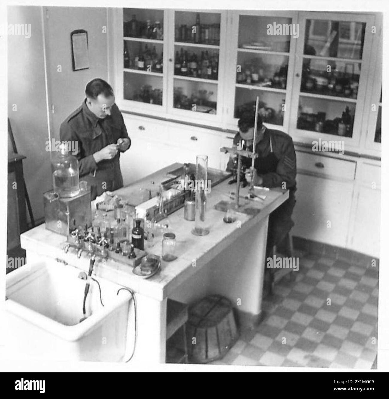 Le sergent J. Milet et le sergent W. Munro examinent des échantillons de sang au microscope dans un laboratoire pathologique en Afrique du Nord, qui fait partie des opérations médicales de l'armée britannique. Banque D'Images