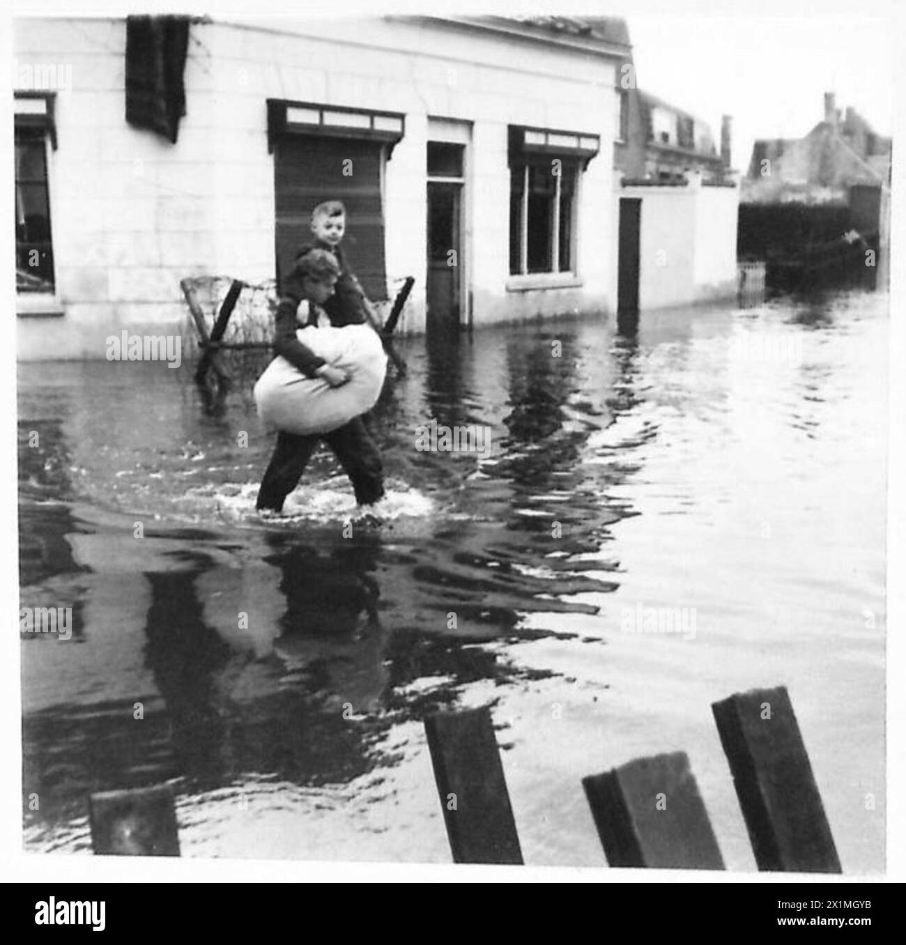 L'ÎLE INONDÉE DE WALCHEREN - où l'eau n'est pas trop garder, les gens peuvent patauger, et un enfant est vu être transporté à travers les inondations, British Army, 21st Army Group Banque D'Images
