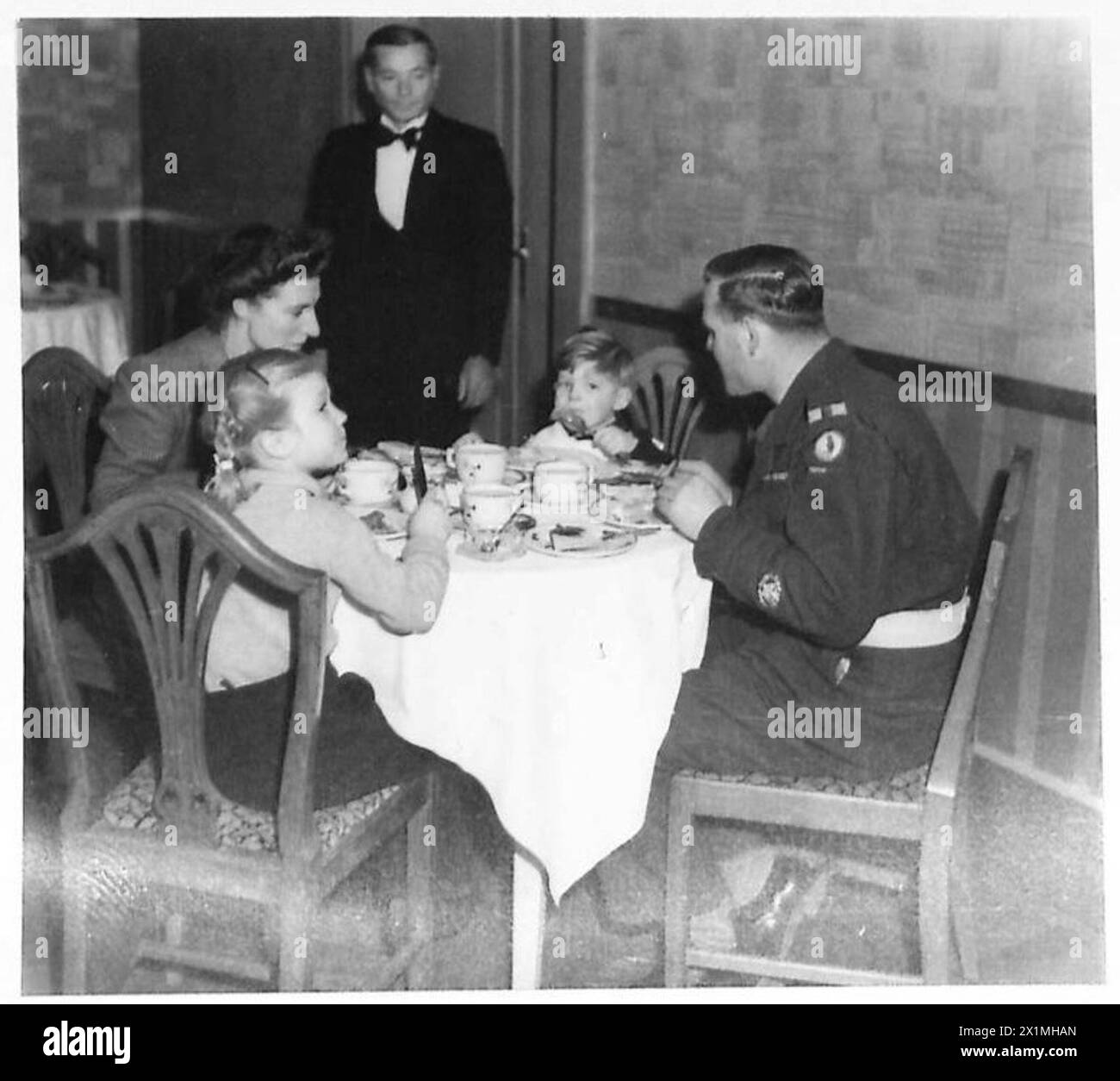 Le MQMS Hayley du 2e Bataillon R.T.R. prend le petit déjeuner avec sa femme et ses enfants à l'hôtel Regina, Trieste, le 16 janvier 1946, après être arrivé de Londres avec sa famille, l'armée britannique. Banque D'Images