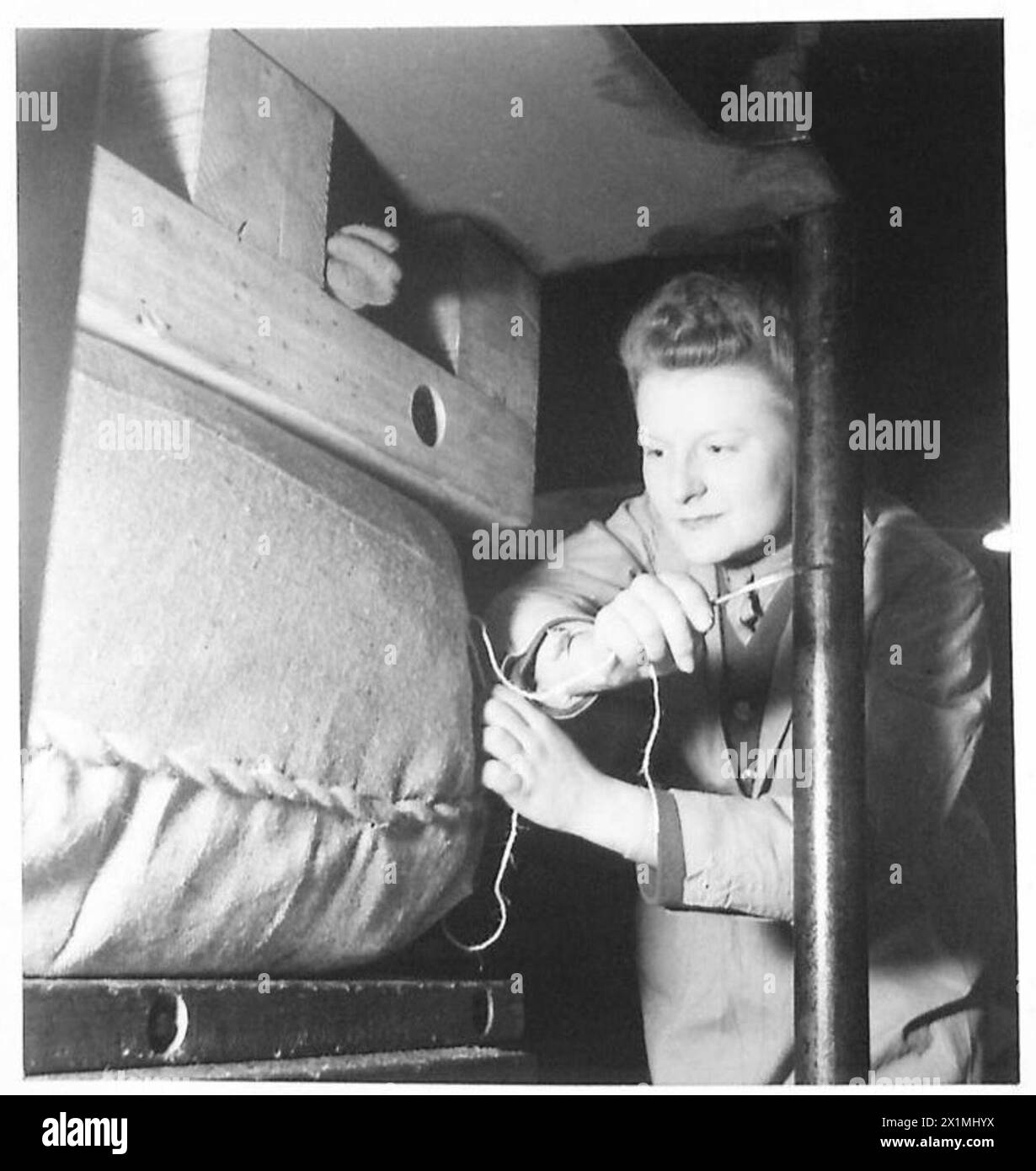 Un magasin ATS utilise des presses à balles électriques pour comprimer des balles de manteaux dans un dépôt de munitions, réduisant ainsi la taille et les coûts de transport sous la supervision de l'armée britannique. Banque D'Images