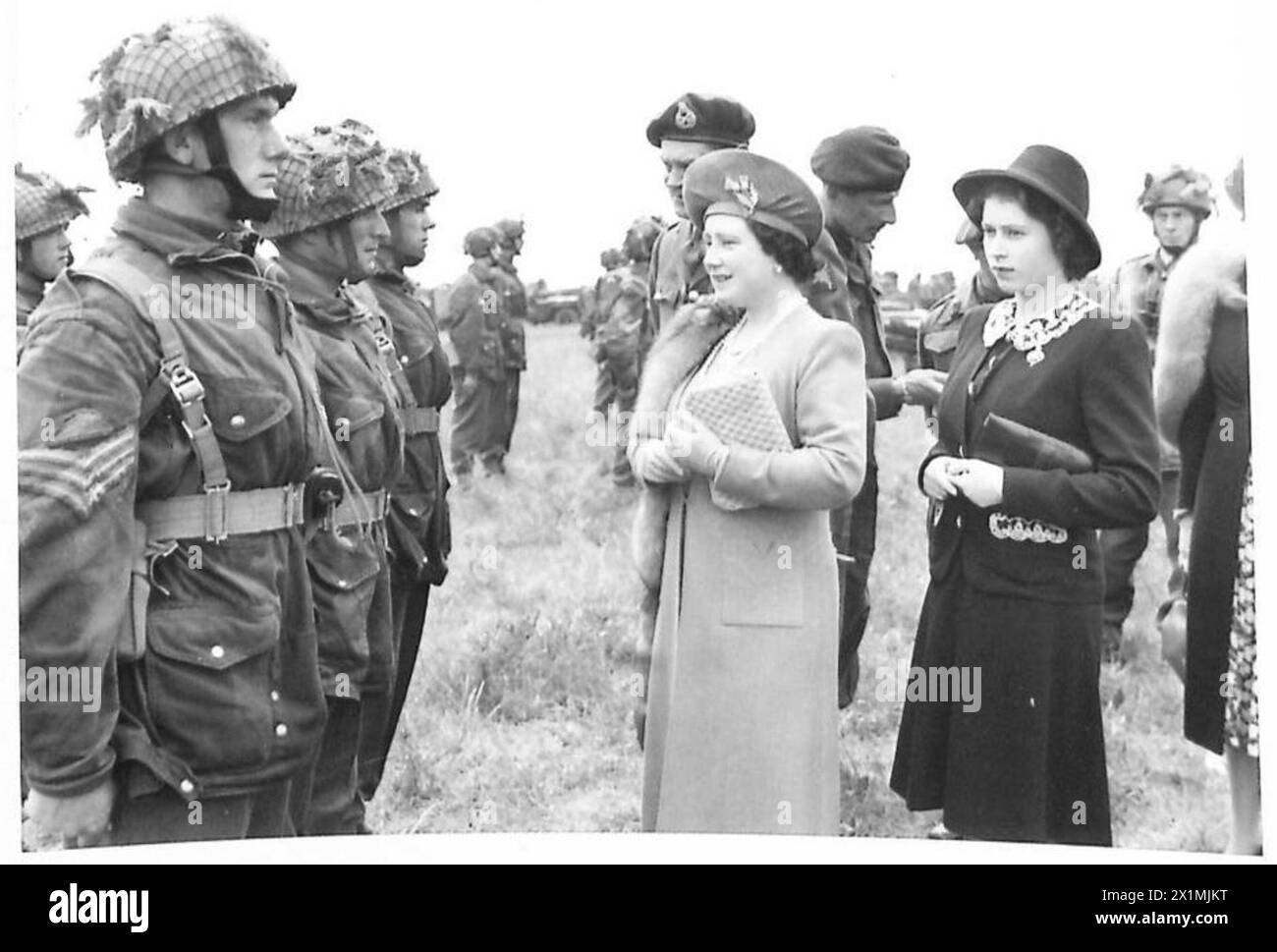 La reine et la princesse Elizabeth parlent avec les troupes aéroportées, soulignant l'engagement royal et le soutien moral des parachutistes de l'armée britannique. Banque D'Images
