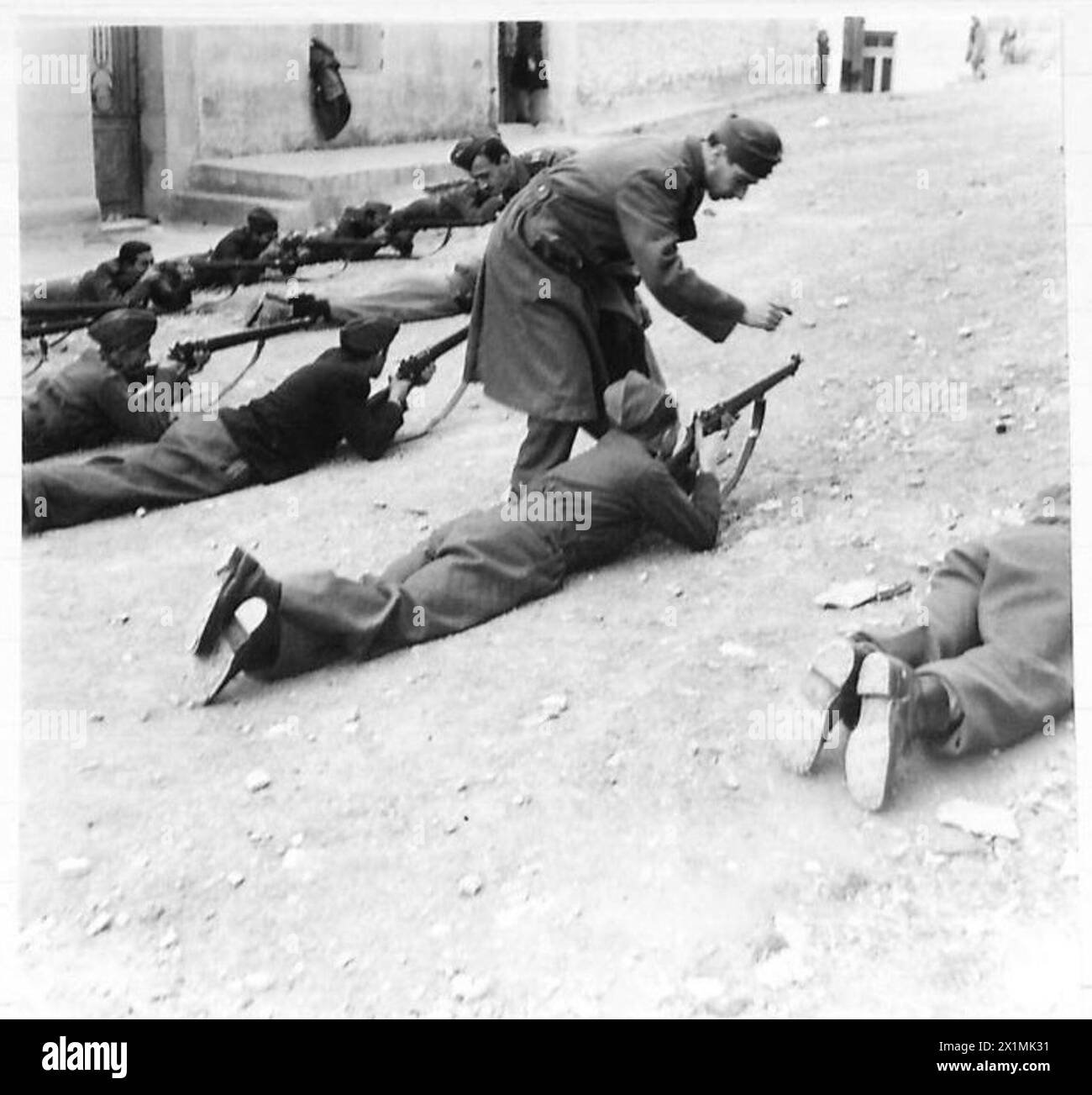 Les gardes nationaux à Athènes sont représentés recevant des instructions de fusil de sous-officiers (N.C.OS) de l'armée régulière grecque au cours des dernières étapes des opérations de nettoyage en Grèce. La photographie capture le processus d'entraînement, mettant en évidence la collaboration entre l'armée britannique N.C.OS et les forces grecques pour améliorer l'efficacité des gardes nationaux. Banque D'Images