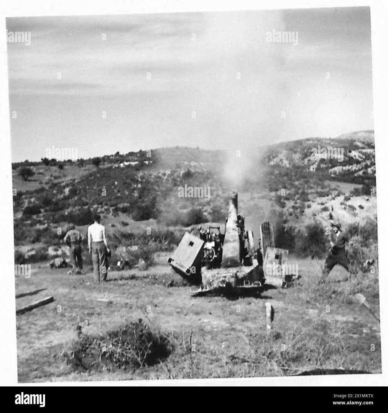 ARTILLERIE LOURDE BRITANNIQUE EN ACTION SUR LE FRONT MEDJEZ-EL-BAB TUNISIE - FEU ! Le recul formidable est illustré sur cette photo par les boucliers derrière les roues, comme on peut le voir ils sont jetés complètement au-dessus du sol sur la gauche, l'un des membres de l'équipage est dépouillé à la taille, British Army Banque D'Images