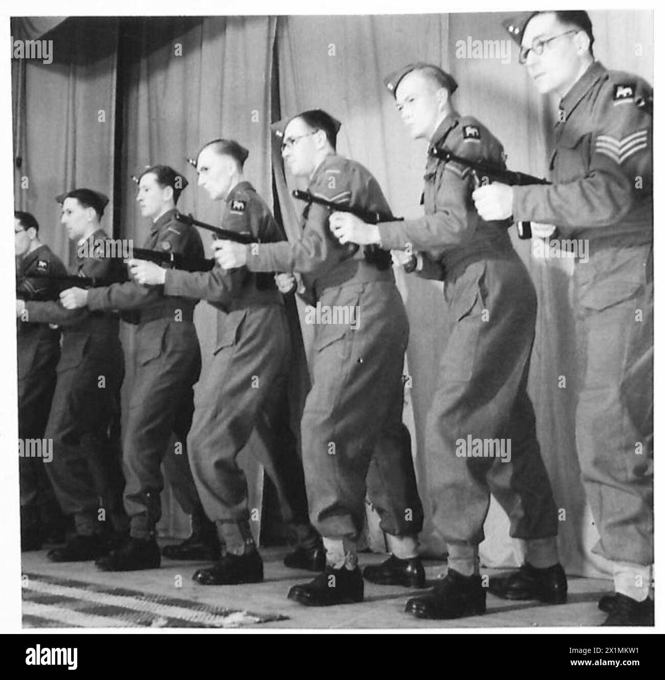 Les soldats de l'armée britannique reçoivent des instructions sur la manipulation et le fonctionnement des canons Tommy de la part des commis de la paye pendant les exercices d'entraînement militaire. Banque D'Images