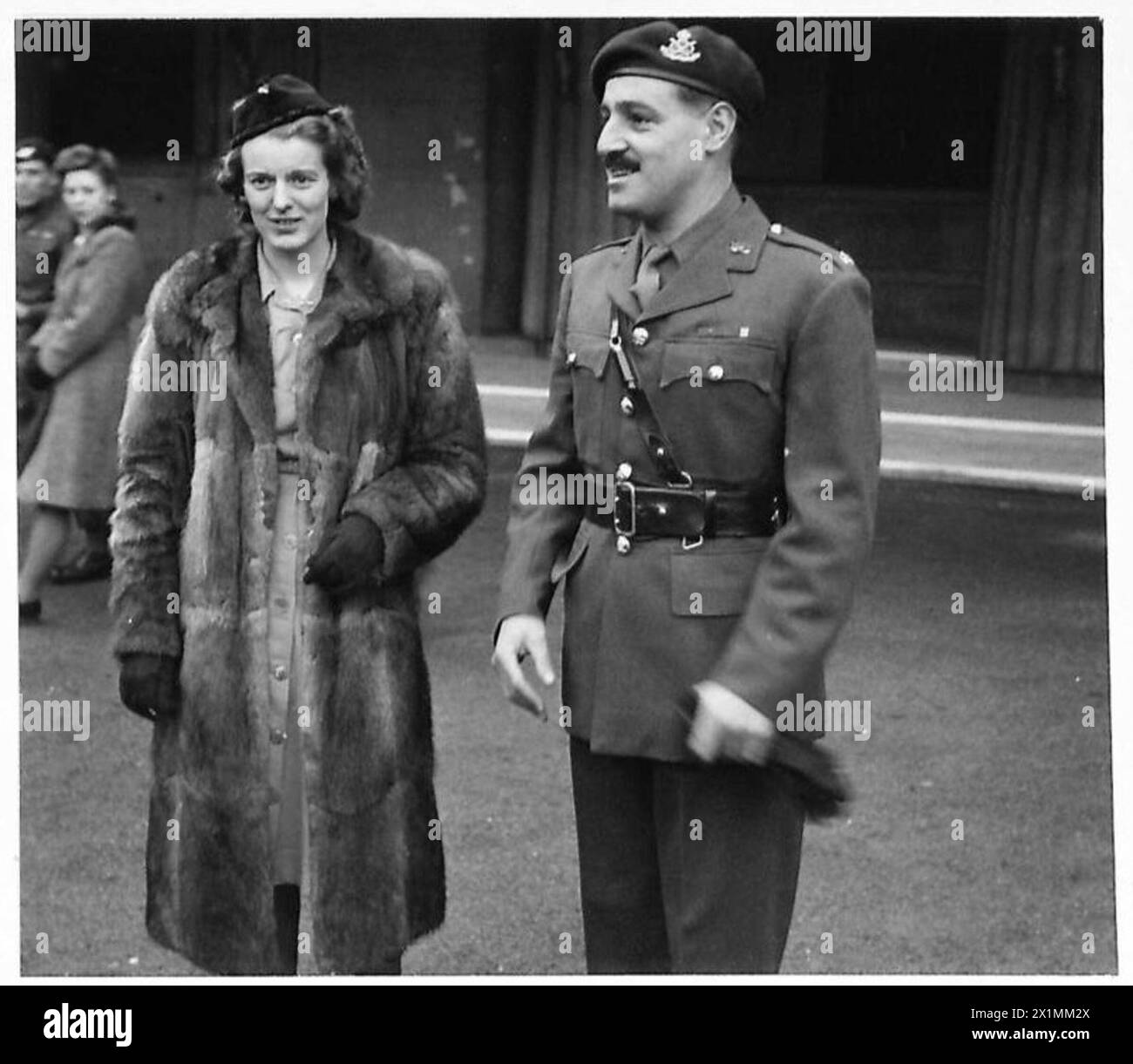 Le major Robert Cain du South Staffordshire Regiment reçoit une décoration du roi au palais de Buckingham pour ses actions à Arnhem, accompagné de sa femme qui est présentée à la reine. Banque D'Images