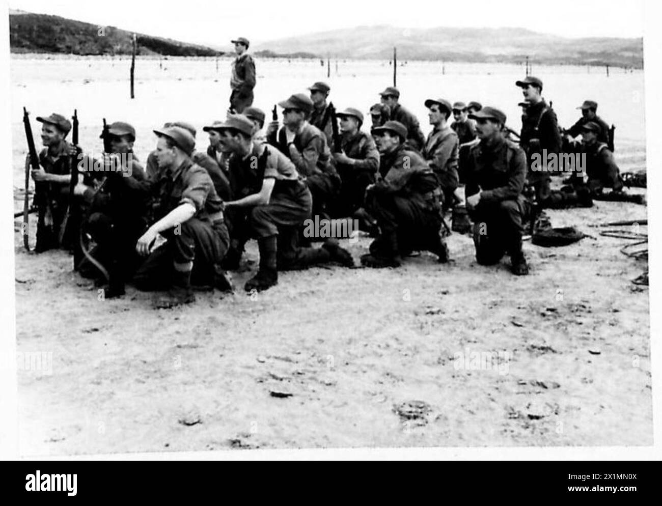 Les soldats britanniques surnommés les « diables verts » observent leurs camarades descendre la plage lors d'une opération amphibie. Banque D'Images