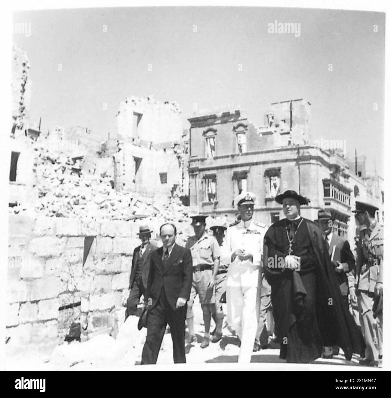 M. LE ROI VISITE L'ÎLE DE G.C. - sa Majesté avec le prêtre de paroisse visitant les zones bombardées, armée britannique Banque D'Images