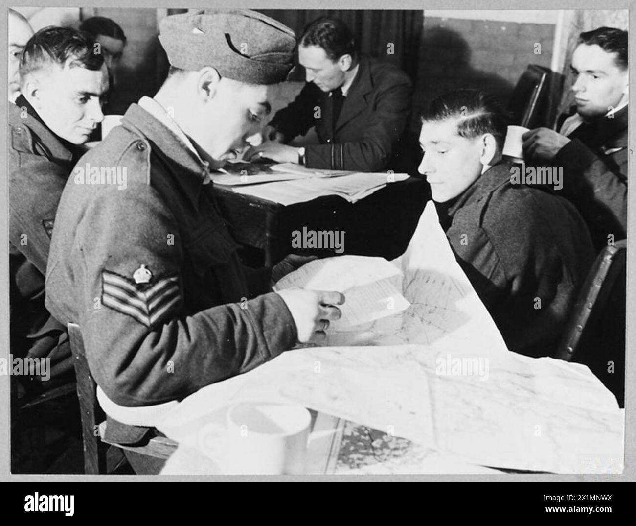 2500 TONNES DE BOMBES SUR BERLIN - pour introduction voir CH.12560 photo (publiée en 1944) montre - le capitaine de l'un des bombardiers Lancaster prenant part à l'attaque sur Berlin vérifie son journal de bord pendant l'interrogatoire, Royal Air Force Banque D'Images