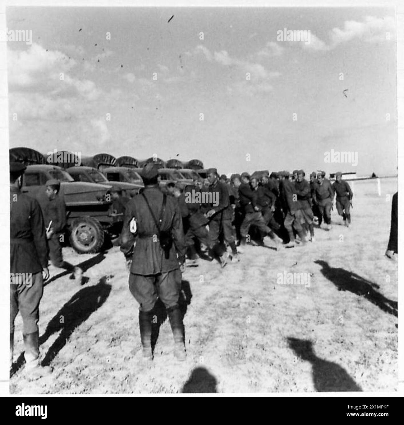 Les officiers russes donnent des ordres et les chauffeurs russes préparent les véhicules pour le mouvement tandis que le personnel de l'armée britannique supervise les opérations d'approvisionnement à la Russie. Banque D'Images