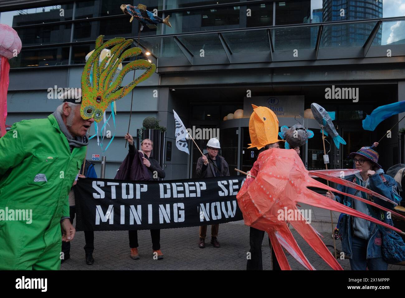 Londres, Angleterre, Royaume-Uni. 17 avril 2024. Ocean Rebellion (OR) organise un concert de protestation contre un sommet minier en haute mer au Hilton de Canary Wharf, soulignant ses effets néfastes sur la vie marine. L'exploitation minière en haute mer, qui consiste à extraire des ''˜nodules de manganèse' des fonds marins pour les utiliser dans des technologies vertes, est considérée comme causant des dommages importants à l'environnement. Il prive les fonds marins de toute vie, libère des panaches de sédiments et crée du bruit qui désoriente les animaux marins. La pollution sonore causée par l'exploitation minière en haute mer est des centaines de fois plus forte qu'un lancement de fusée spatiale. Un poux minier en haute mer Banque D'Images