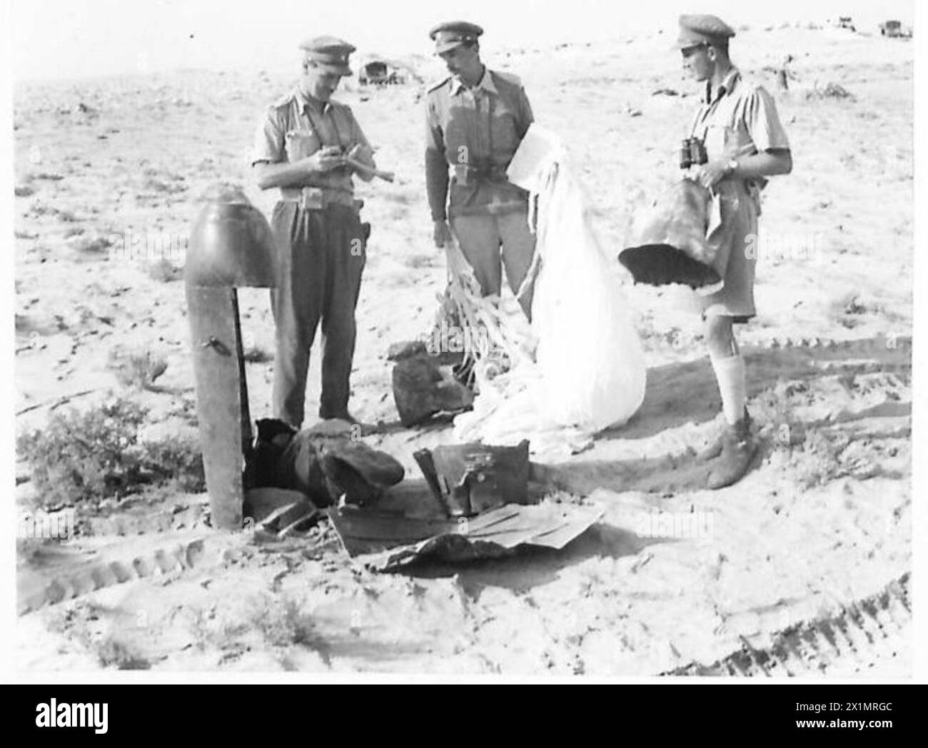 Des officiers britanniques examinent un parachute allemand sur le front occidental qui contenait des munitions et n'a pas réussi à se déployer, montrant la récupération d'équipement en temps de guerre. Banque D'Images