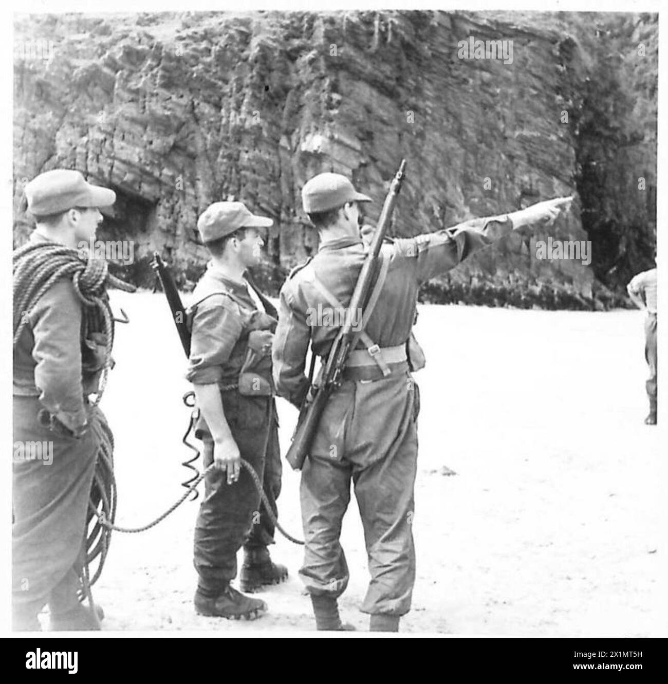 L'avant-garde des Green Devils reçoit des instructions sur l'escalade et la navigation sur une falaise pendant les opérations de l'armée britannique. Banque D'Images
