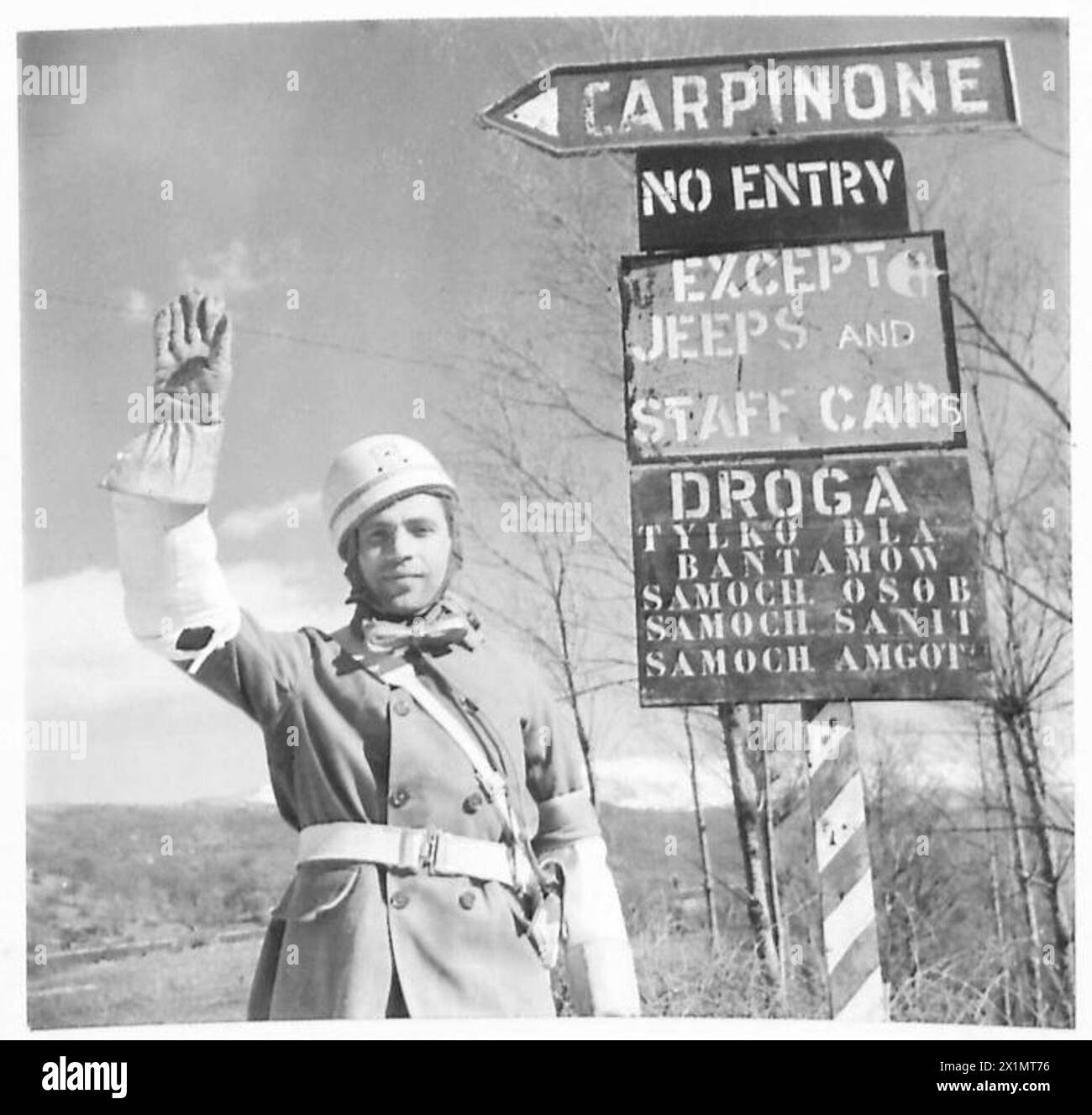 Czesław Łoskowski du 3e escadron de police militaire de la 3e division de carabines des Carpates, 2e corps polonais, dirige la circulation par un nouveau panneau de signalisation polonais près d'Agnone le 4 mars 1944 pendant les opérations de campagne italienne. Banque D'Images