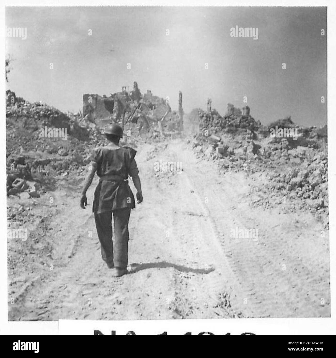 Un membre d'équipage de chars canadiens traverse la ville déserte et endommagée de San Angelo en Italie lors d'opérations sur la ligne Gustav. Banque D'Images